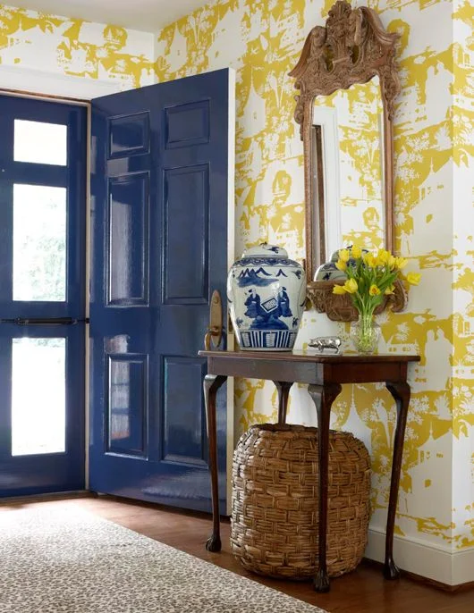 Citrine wallpapered entry. Striking contrast with the glossy blue painted door.