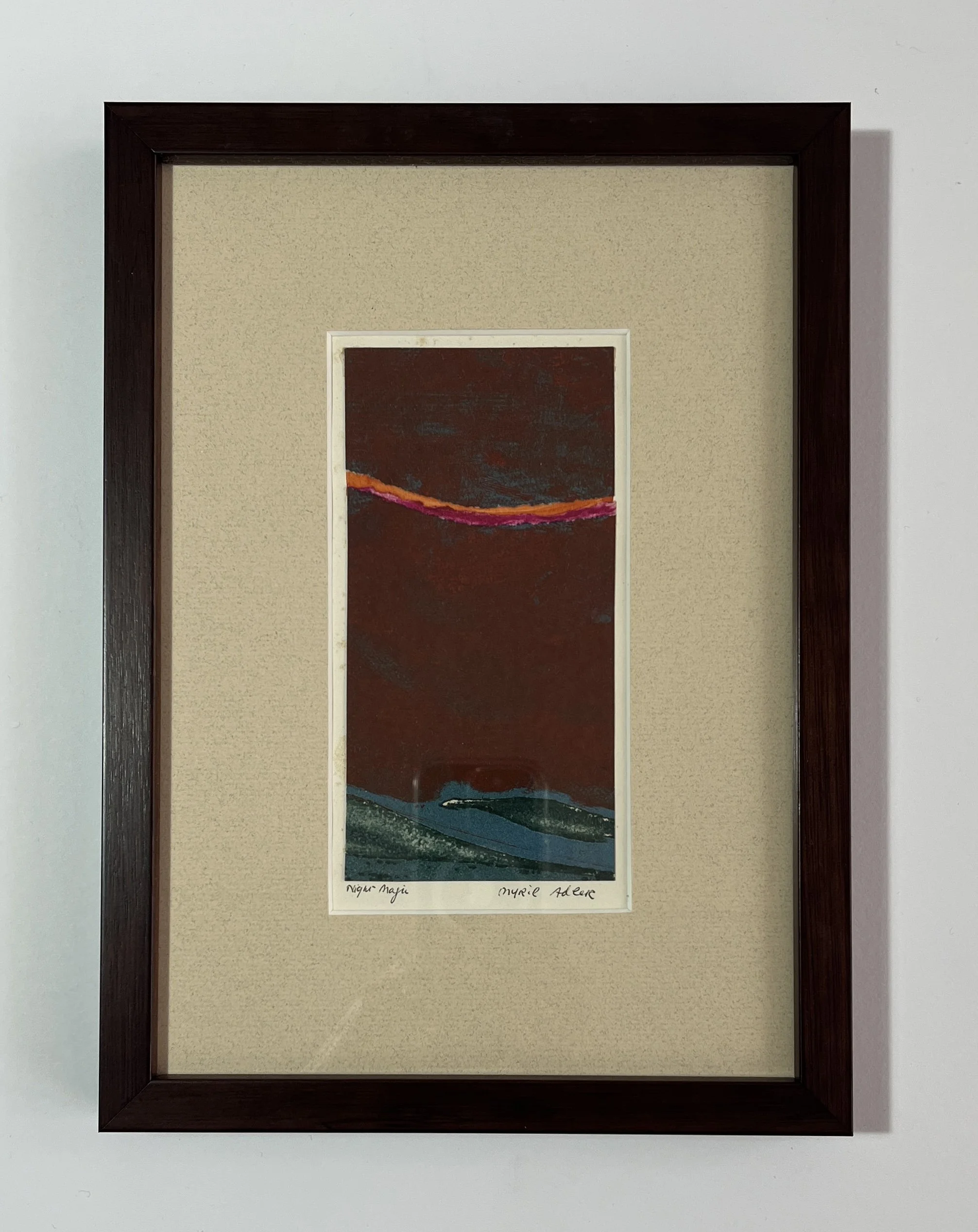 A framed abstract artwork featuring a dark sky with a pink and orange streak, and dark blue and green hills at the bottom.