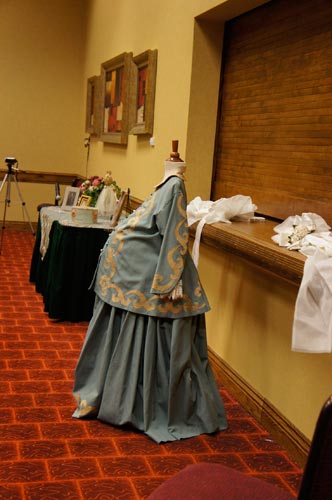 The Victorian decorations includes gloves, hat boxes, a baby carriage, dolls and even this maternity gown.