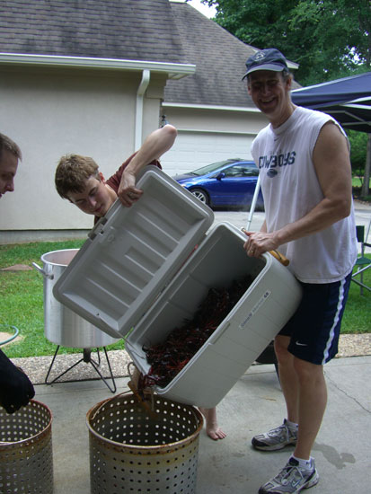   Greg teaching the boys the ropes. Our nephew is on the left side of the pic. He's wearing mitts so he can scoop the live crawfish into the cook pot. Our oldest son (in the middle) is helping Greg with the cooler. That thing is heavy with all those 