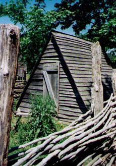   This is the hen house enclosed by a twilled, wooden fence comprised of thin rails passing over and under sturdy posts.  