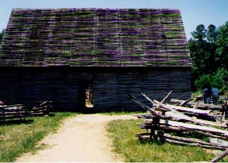   This is a tobacco barn. You can't really tell from this picture, but there is a bit of space between each log. This allows air to flow through the building while the tobacco dries.  