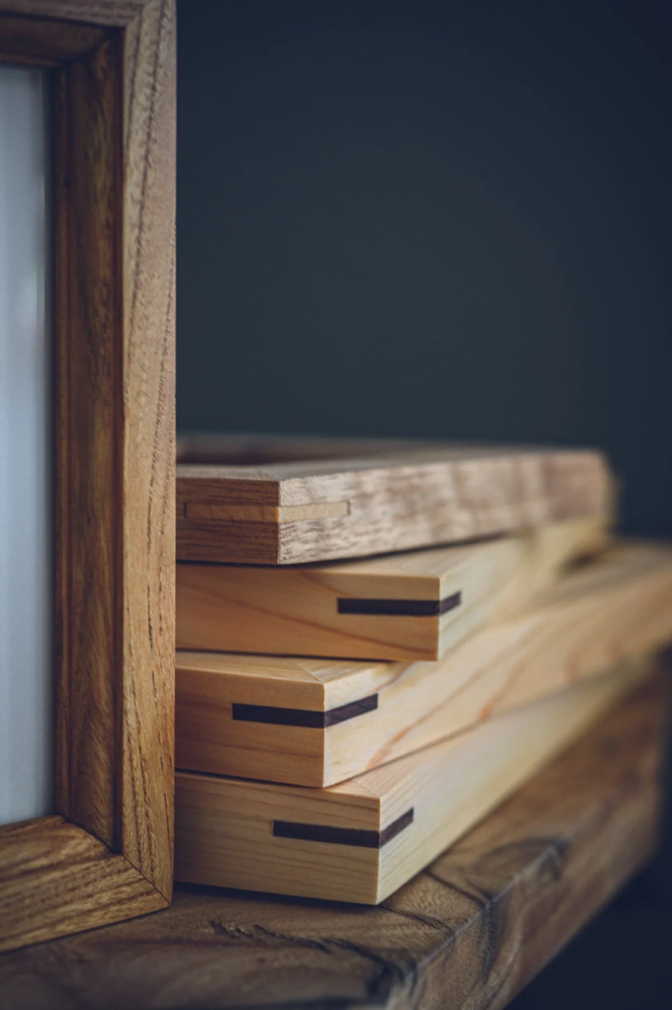 Close-up of wooden cutting boards stacked on a wooden surface.