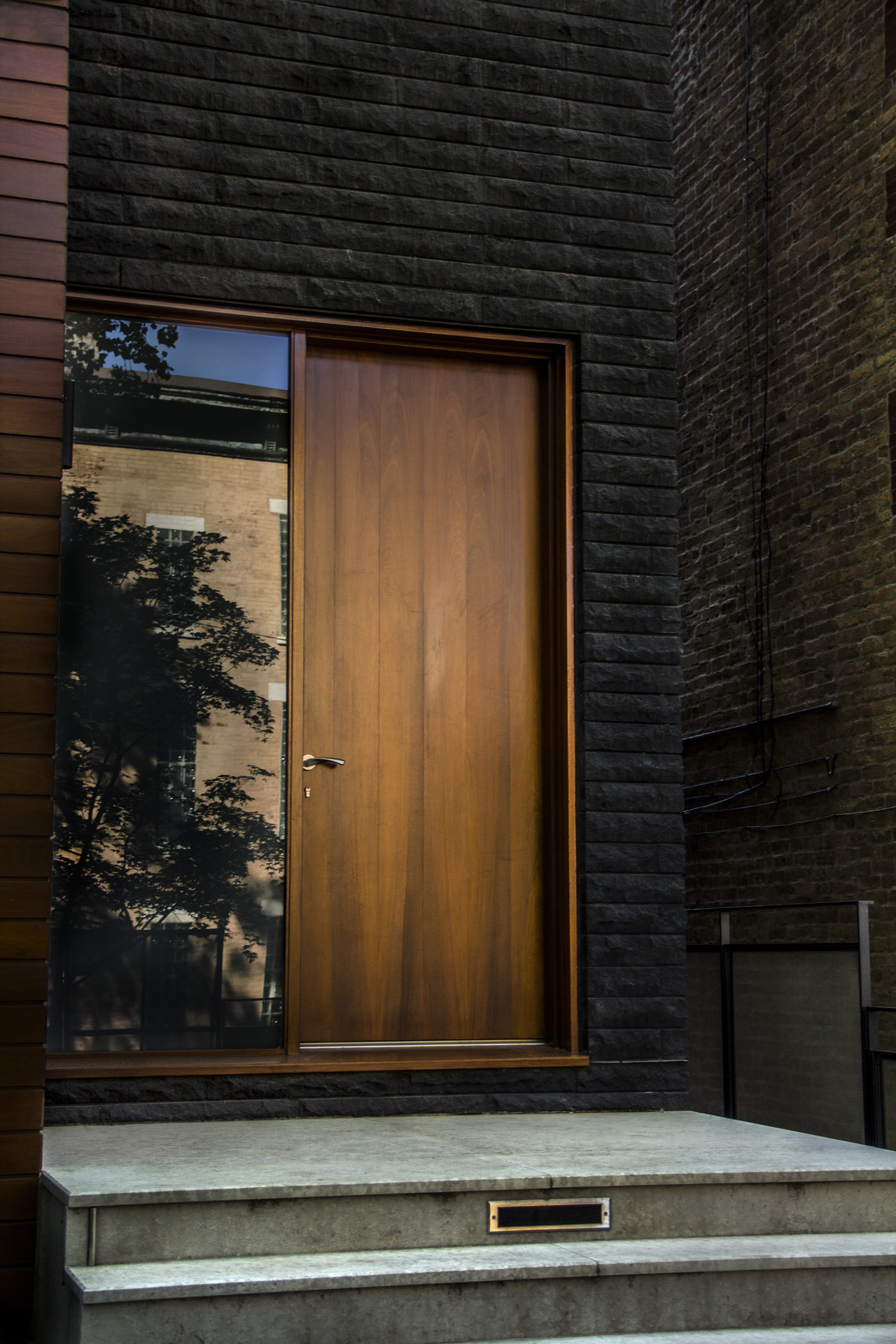 Dark bricked wall with wooden door constrast ITCHBAN.com
