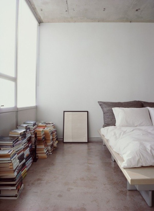Loft styled bedroom with stacks of books ITCHBAN.com