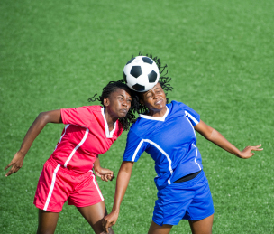 Two female soccer players competing for the ball, aerial view.
