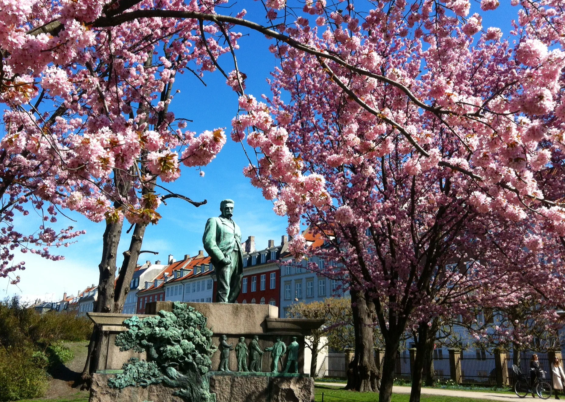 Kongens Have en solskinsdag i april med blomstrende træer og Viggo Hørup, der skuer ud over folk, der slikker solskin i sig, børn i klapvogne, hundeluftere, turister - og alle os andre. Hvad mon han tænker? 