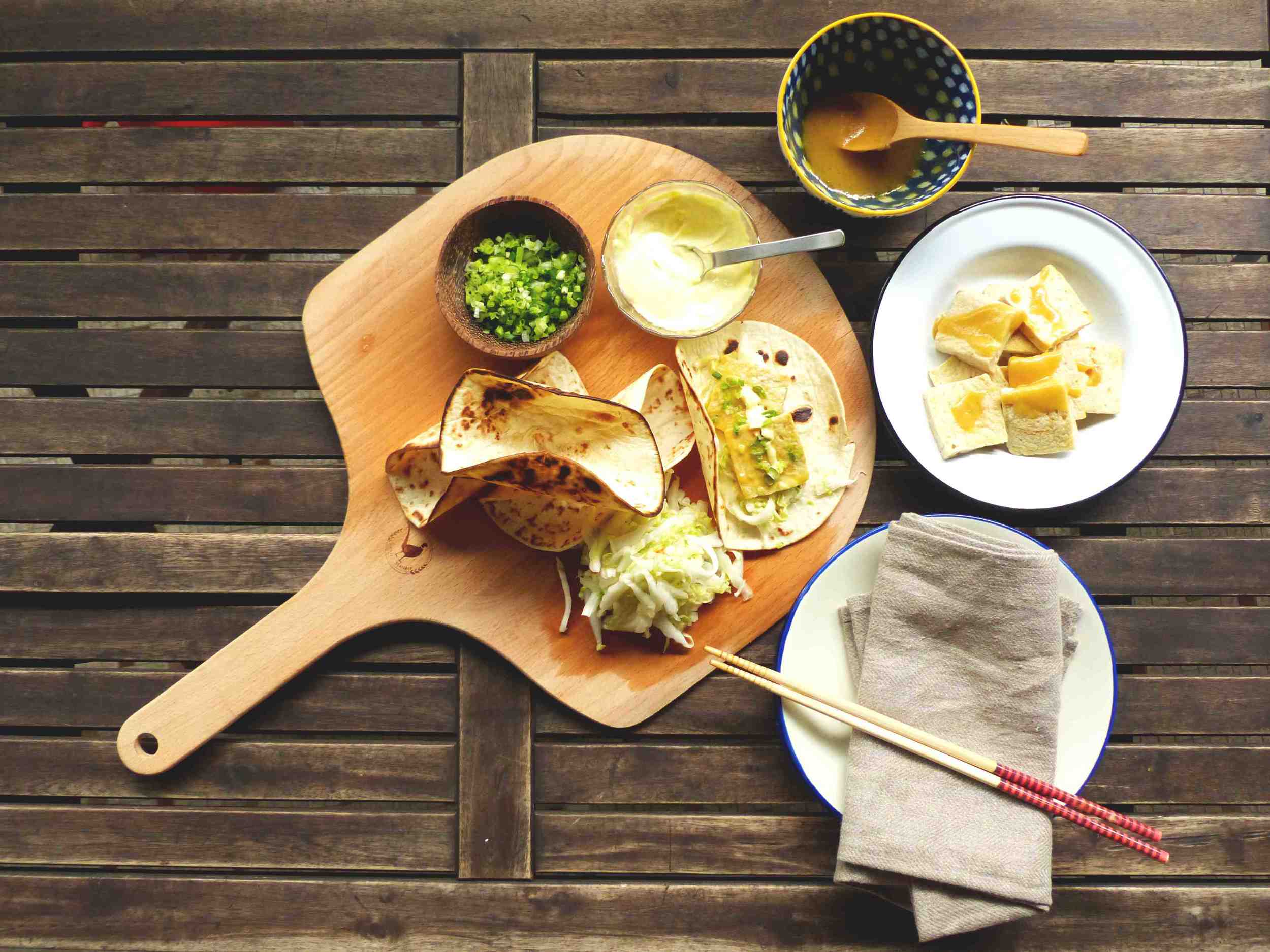 To make each wrap, add a dollop of wasabi mayonnaise, smear evenly on the base of each tortilla wrap, then add the spicy chinese cabbage pickle. Dip the tofu in the miso sauce and transfer 2-3 tofu cubes to each tortilla wrap. Add another drop of wasabi mayonnaise on top. Garnish with chopped spring onion and coriander. Add a twist of lime juice if you like. 