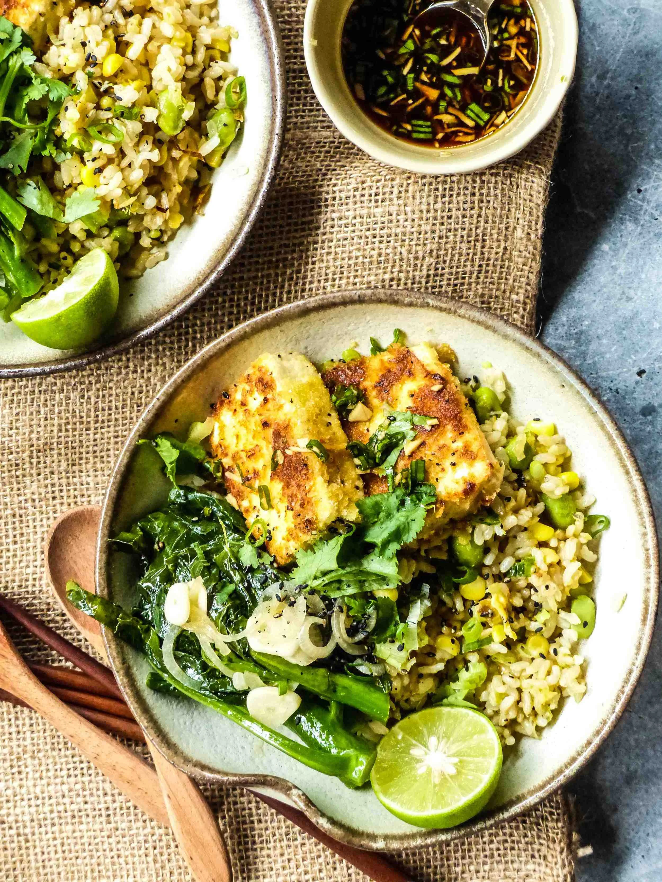 Servings: 2 persons Preparation Time: 5-10 minutes Cooking Time: 15-20 minutes Ingredients: For fried rice: 2 bowls cooked brown rice 1/2 bowl cooked corn 1/2 bowl edamame 1/2 onion, finely chopped 2 tbsp minced ginger 1-2 tbsp chopped spring onion and coriander extra-virgin olive oil For Chinese Kale: 100-150g Chinese Kale 1/2 vegetarian stock tablet 1 shallot 1-2 garlic cloves extra-virgin olive oil For crispy tofu: 150g hard tofu, squared 1 egg* 1/2 cup breadcrumbs 1 garlic clove, finely chopped 1/2 green chili, finely chopped 1/2 red chilli, finely chopped * some leftover egg can be used for making the fried rice For the sweet and spicy lime sauce: 1/2 lime juice 1-2 tsp honey 1-2 tsp mirin 2 tbsp soy sauce 1-2 tbsp chopped spring onion 1/2 garlic clove, finely chopped 1/2 red chili, finely chopped 1/2 green chili, finely chopped