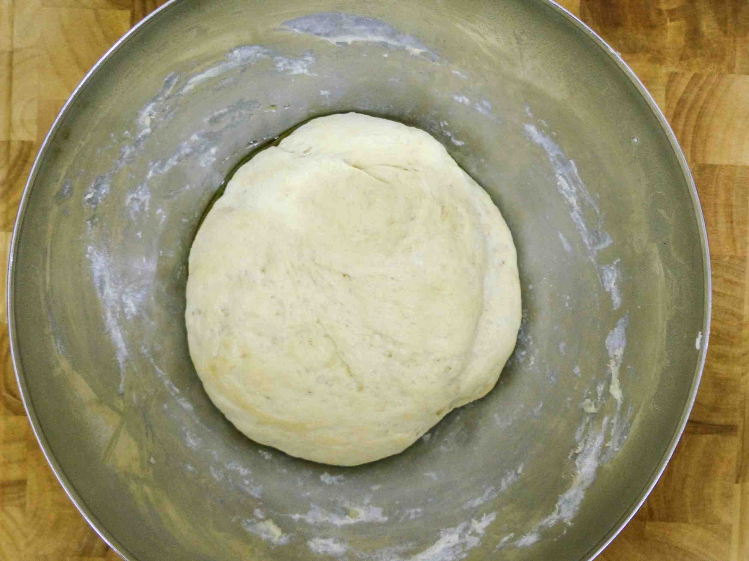After an hour or so, the dough should have doubled its size. Then punch it in the middle to release the extra air inside the dough.