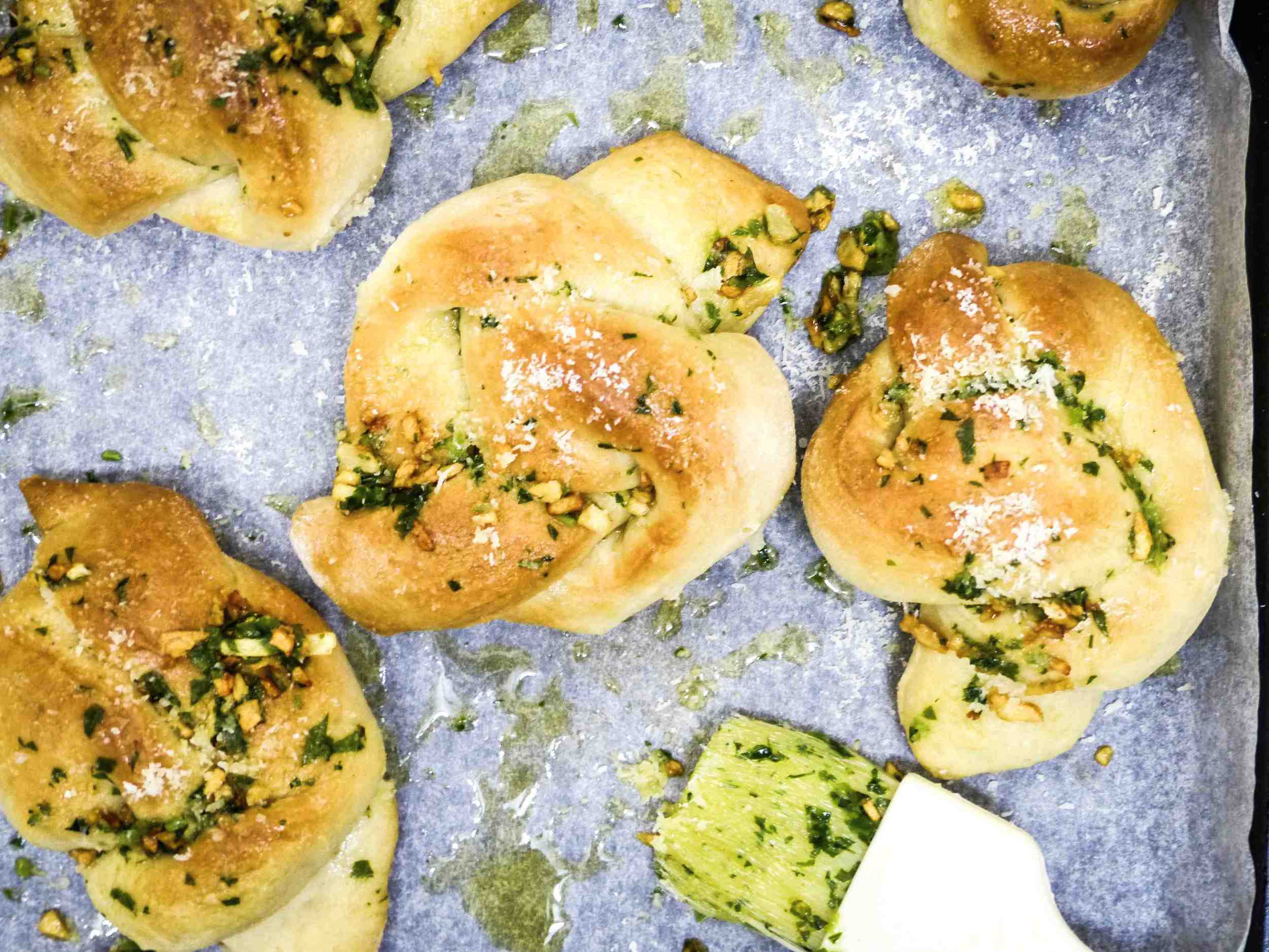 Brushing the garlic butter dressing and sprinkling sea salt and cheese on each knot. 