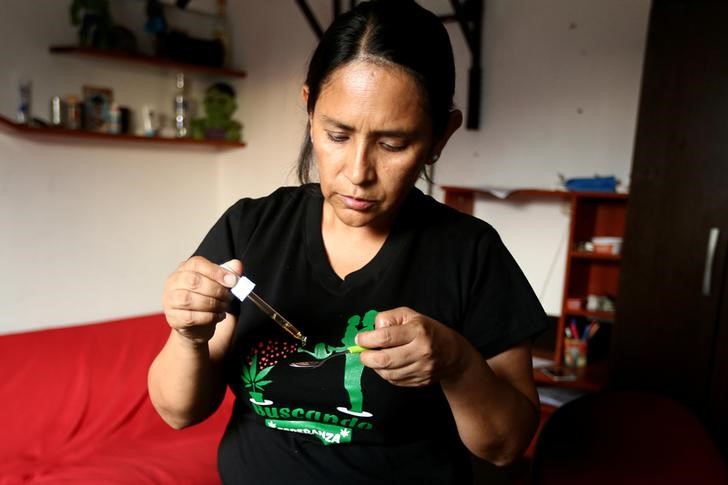 Ana Álvarez sirve una cucharada de aceite de marihuana a su hijo Anthony en su residencia en Lima. Foto de Newspaperon.com. 