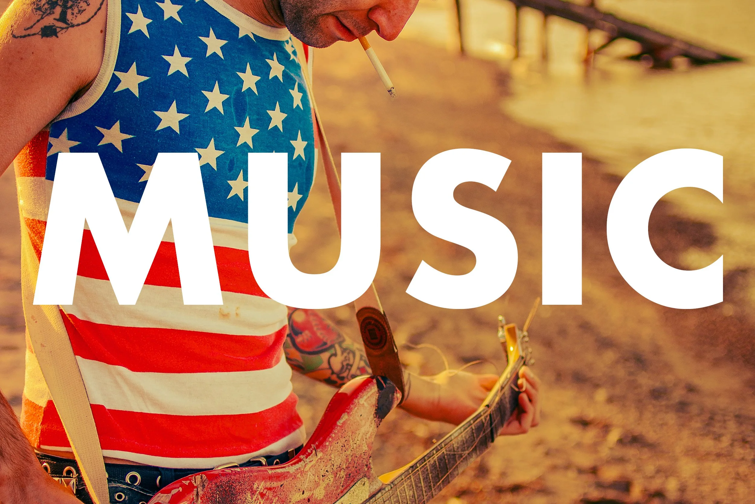 Person wearing a sleeveless shirt with the American flag pattern, holding a guitar, with large white letters spelling 'MUSIC' overlaying the image.