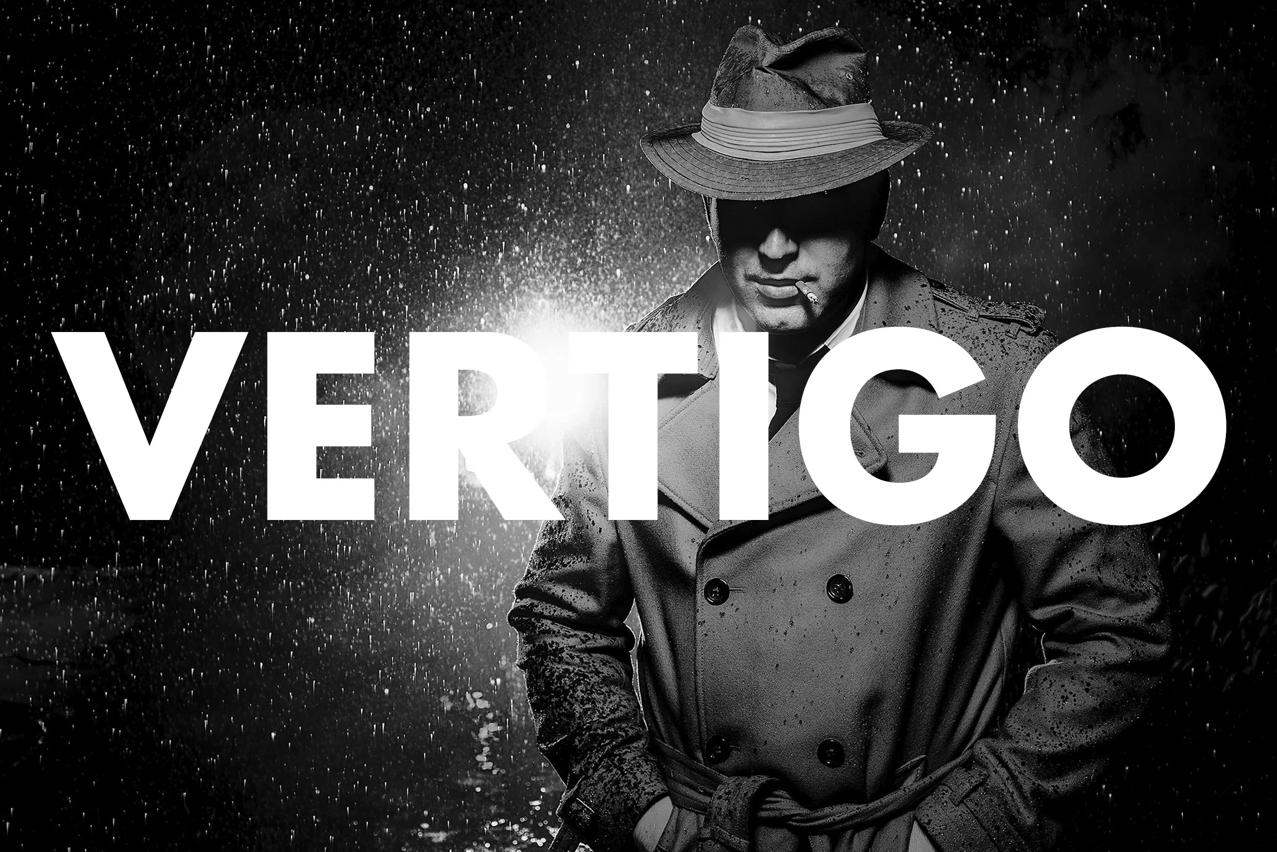 A black and white photo of a man with a cigarette in his mouth, wearing a trench coat and a hat, standing in the rain. The word 'VERITICO' is overlaid in large white letters.