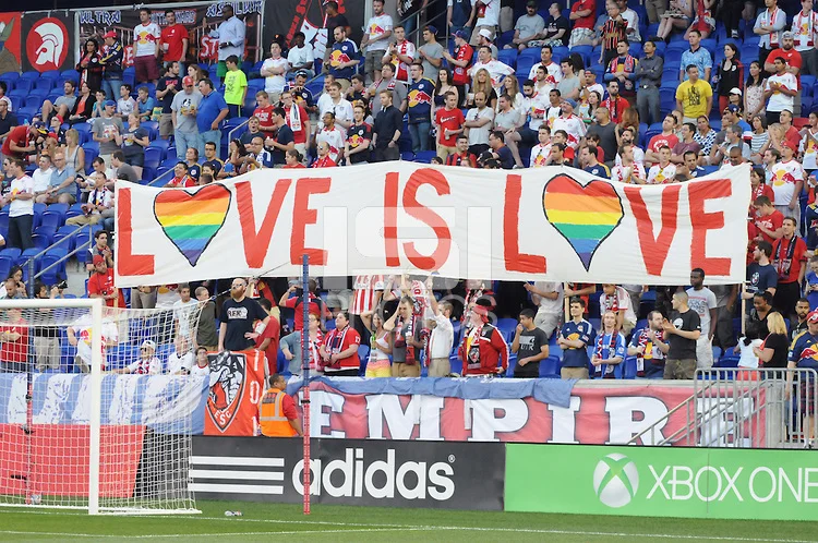 Fans hold up a sign in celebration of Pride Month