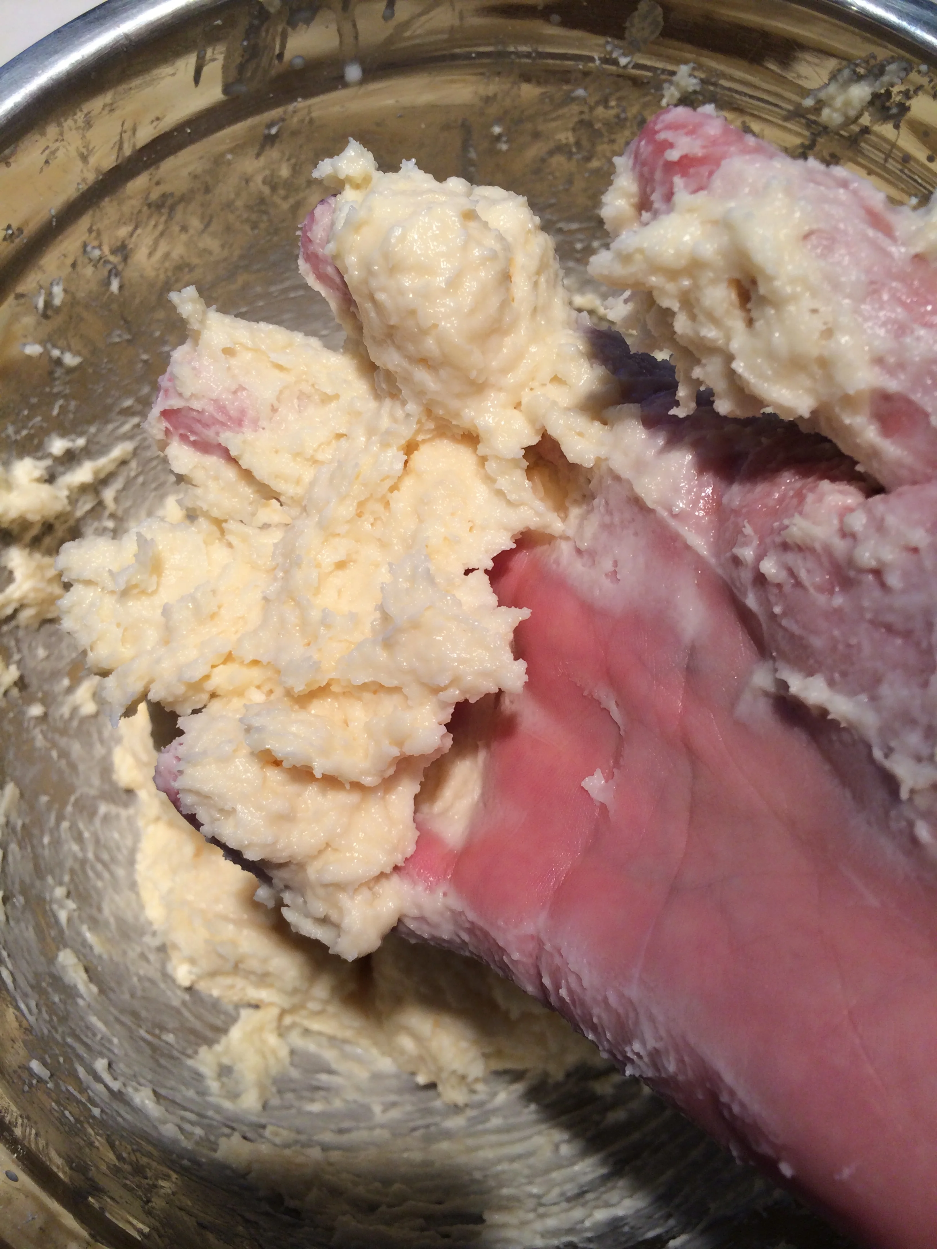 A massa do pão de queijo fica pegajosa nas mãos. Se a sua estiver muito seca, precisará mais leite. Para limpar as mãos, use uma colher de sobremesa pra raspar. 