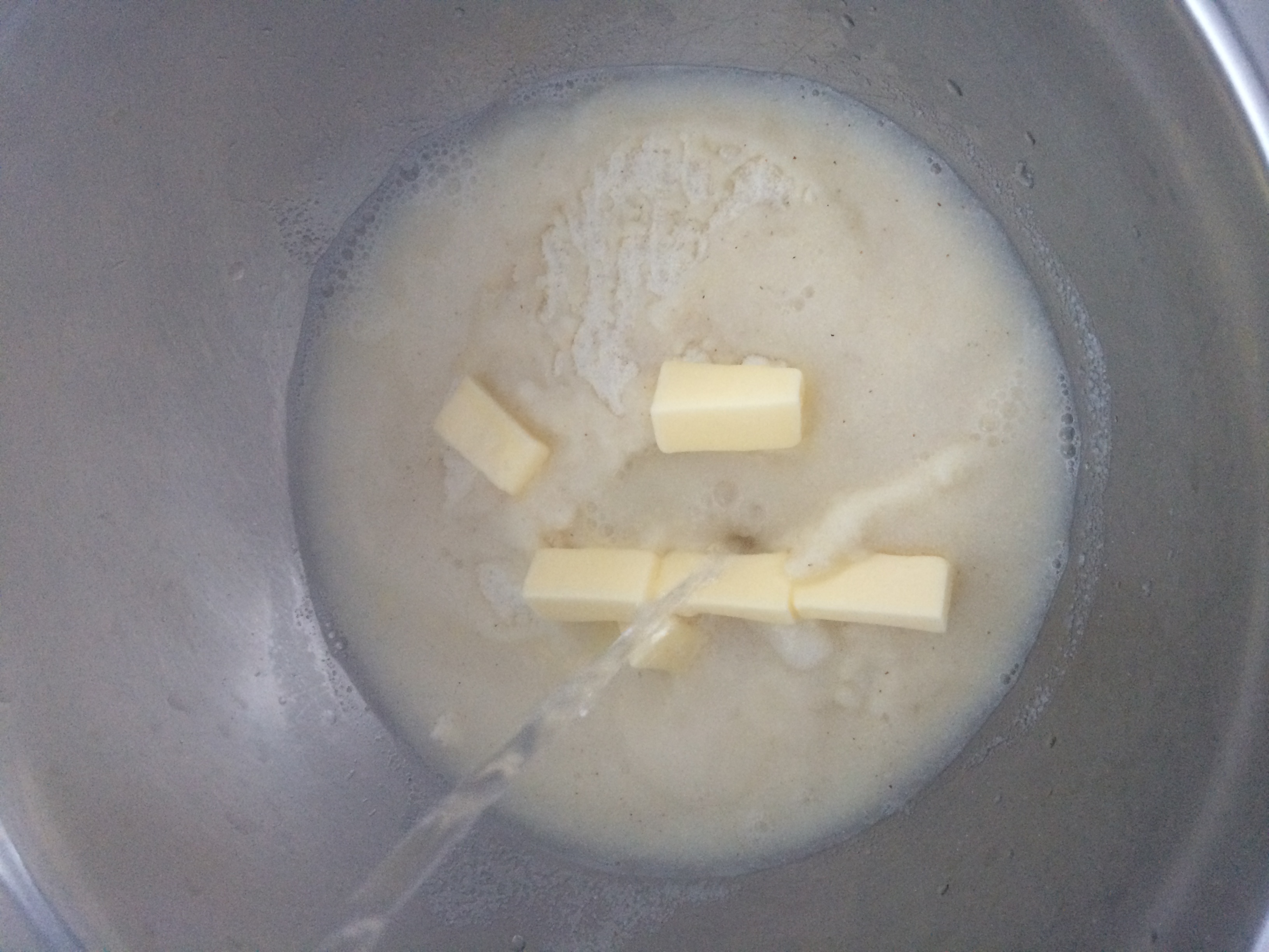 Numa tigela funda, de vidro ou de metal, combine a farinha pré-cozida de milho e a manteiga gelada picada com água quente, misturando bem. Deixe repousar por 5 minutos.