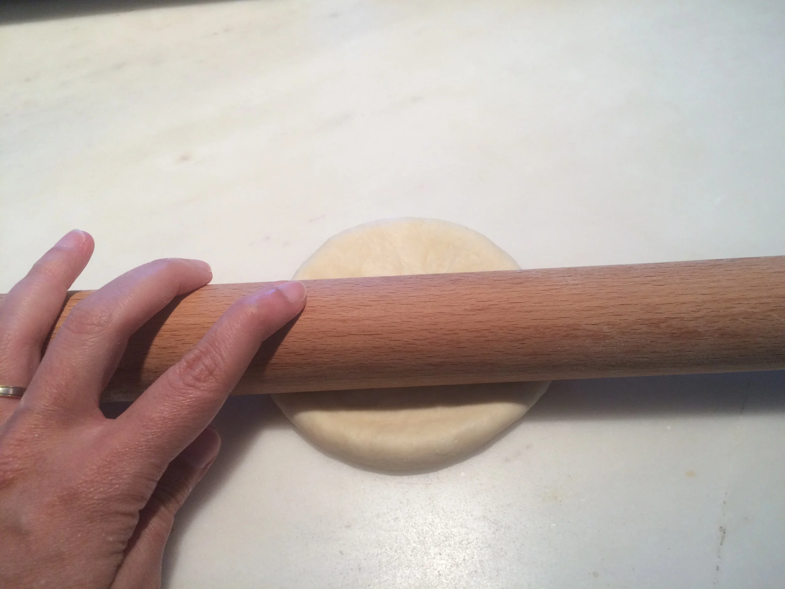 Com a ajuda de um rolo, abra a massa em formato oval para poder enrolar os pães. 