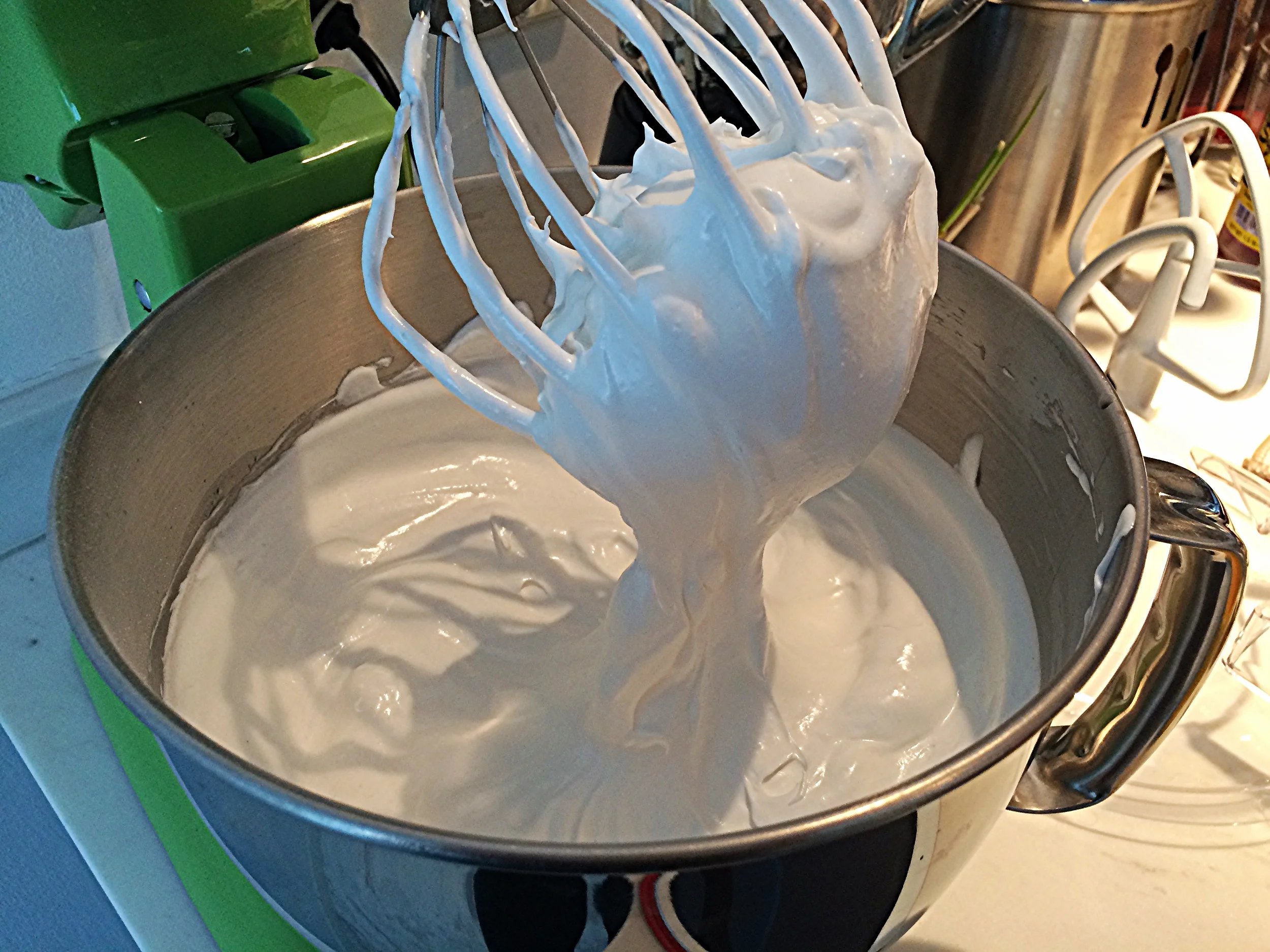 Misture os 50g de açúcar restante ao amido de milho pra facilitar a incorporação. Acrescente a mistura às colheradas, com a batedeira em velocidade baixa, pra não voar amido pra todo lado. Bata até atingir o ponto, que é quando você levanta a cabeça da batedeira e o batedor está cheio de merengue, como na foto.