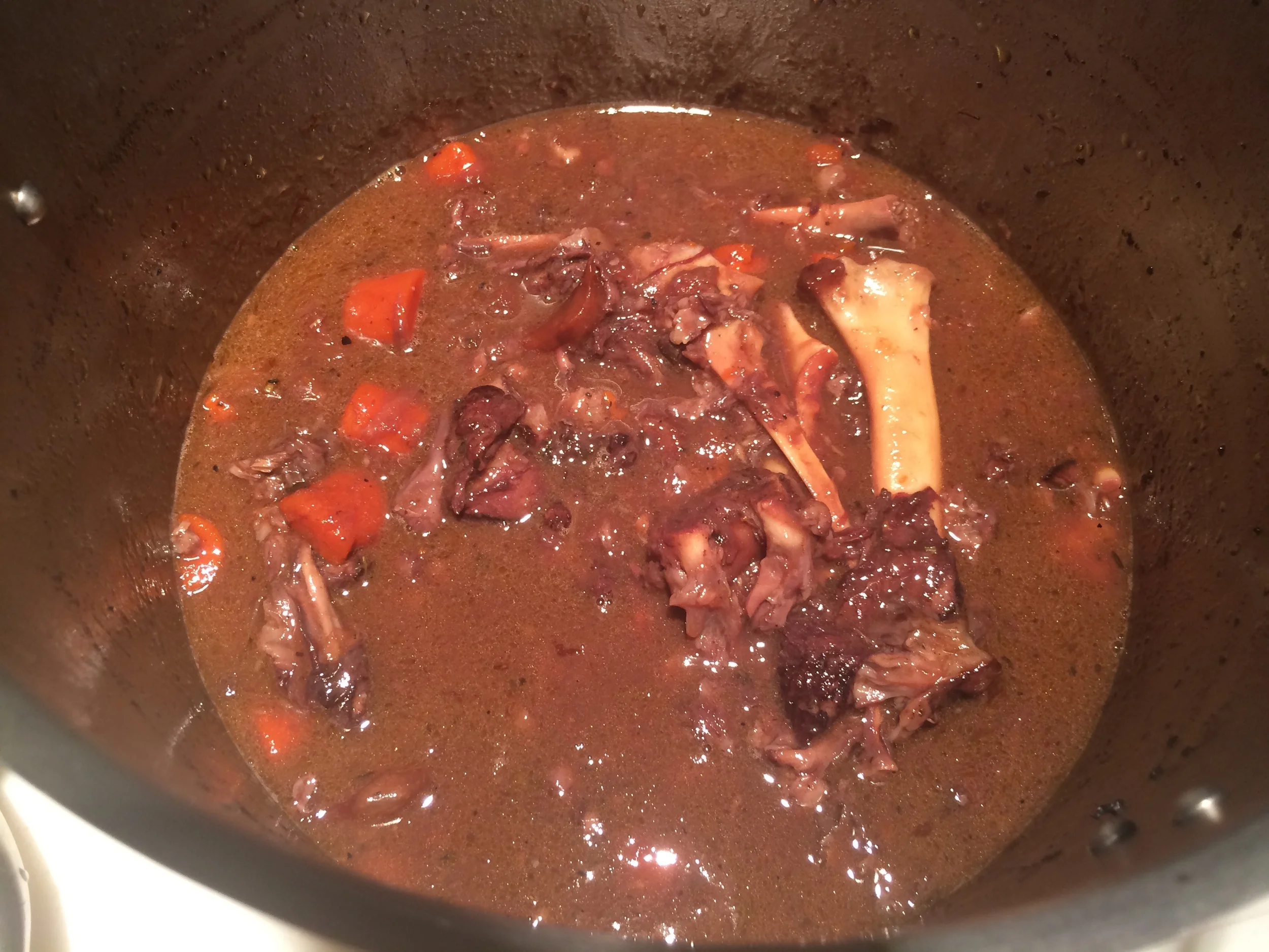 Volte os ossos e o tecido conjuntivo que você separou para a panela, que continuou fervendo durante o período em que a carne esteve fora. Este molho será reduzido pra ser servido junto com a carne. Portanto, quanto mais tempo no fogo, melhor!