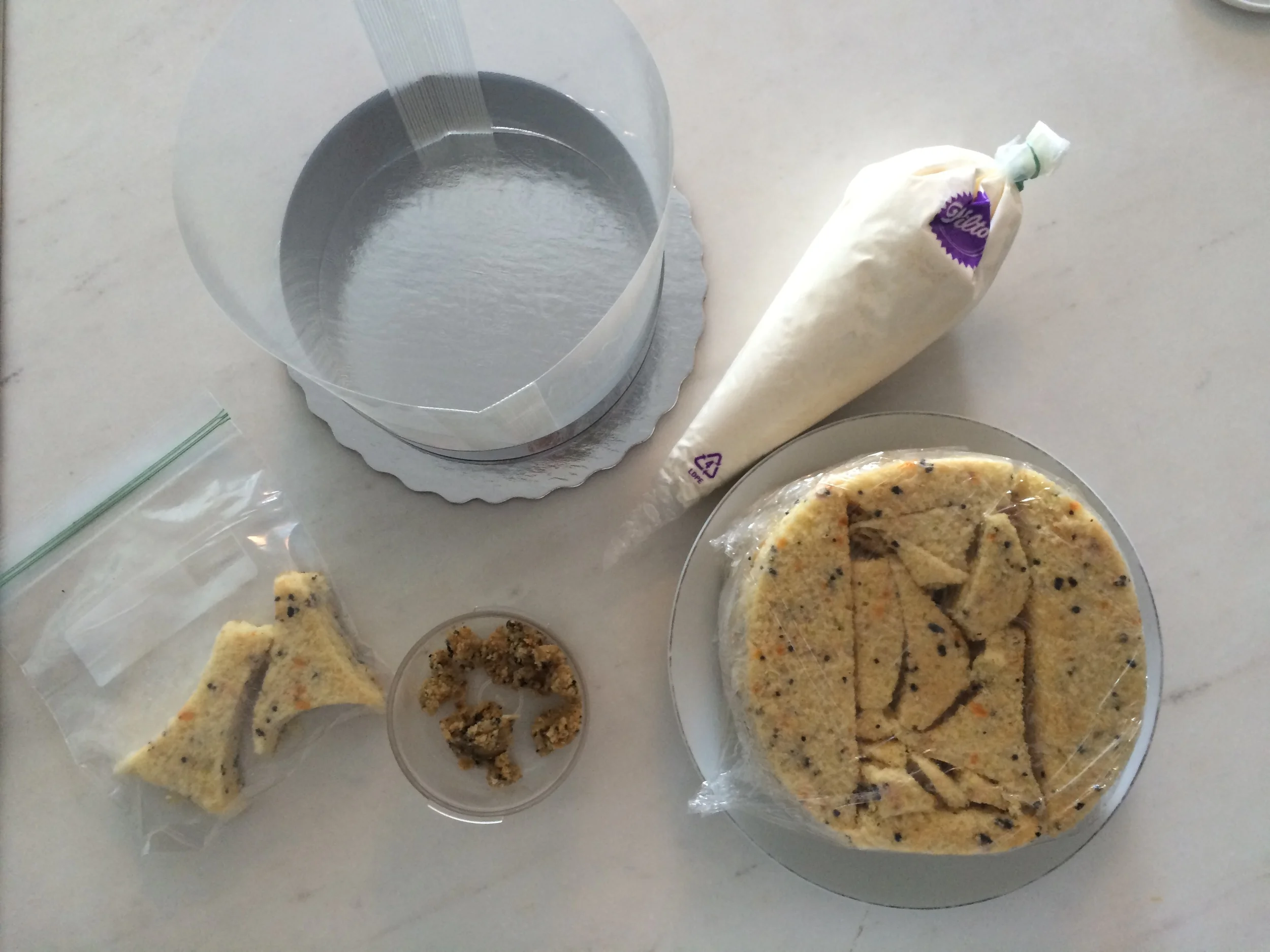 Junte todos os ingredientes do bolo: as fatias cortadas, o creme para recheio e cobertura, os biscoitos e o leite (que eu esqueci de colocar pra tirar a foto). 
