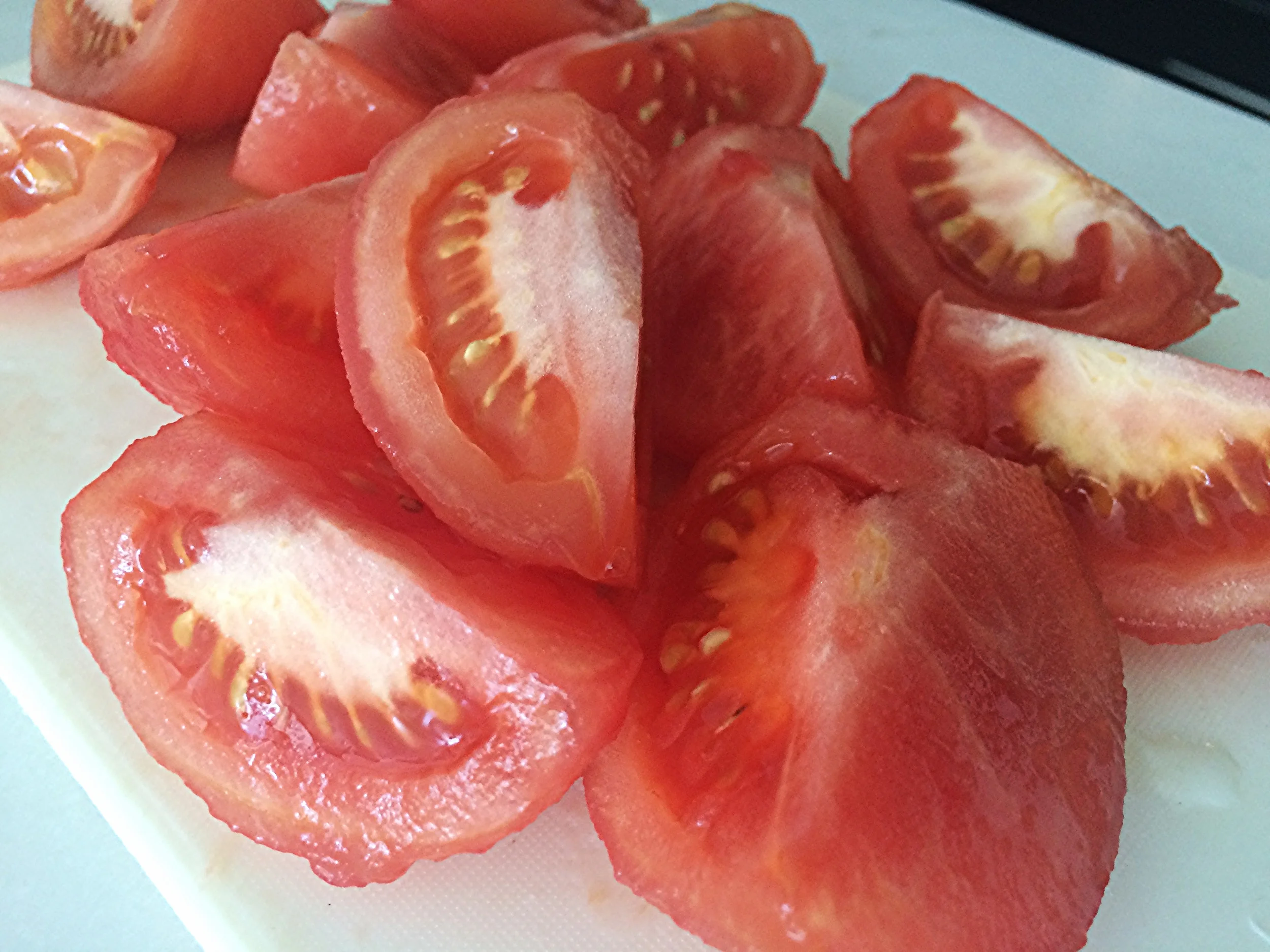 Corte os tomates em quatro e retire aquela parte branca que fica junto onde antes ficava o cabo. Corte-os grosseiramente, com as sementes, e reserve. 