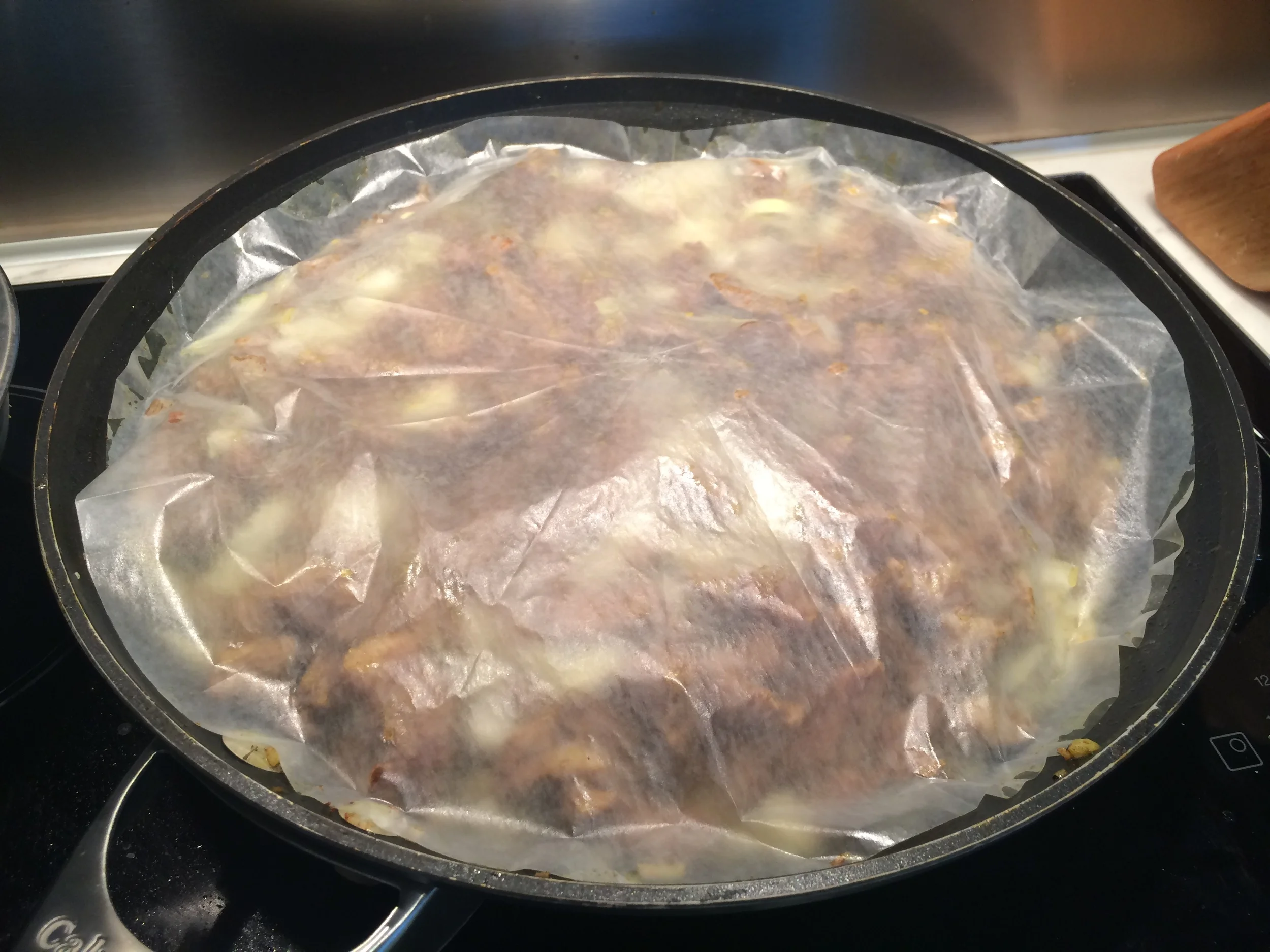 Adicione o caldo de carne até a metade da panela e cubra o preparo com uma tampa feita de papel manteiga . Se a panela que você escolheu usar tem a sua respectiva tampa, é só usar a que você tem. Cozinhe em fogo baixo por aproximadamente 20 minutos. Depois, acrescente as ameixas e cozinhe por mais 20 minutos. Se for preciso, coloque um pouco mais de caldo, sem encharcar. Eu gosto de deixar as ameixas desmancharem bem no molho, de modo que desapareçam os pedaços. Tempere com sal e pimenta. Quase na hora de servir, adicione a salsinha e o coentro, reservando um pouco para colocar por cima, na finalização. Depois de servido, distribua os pinholi e o restante das ervas frescas. 