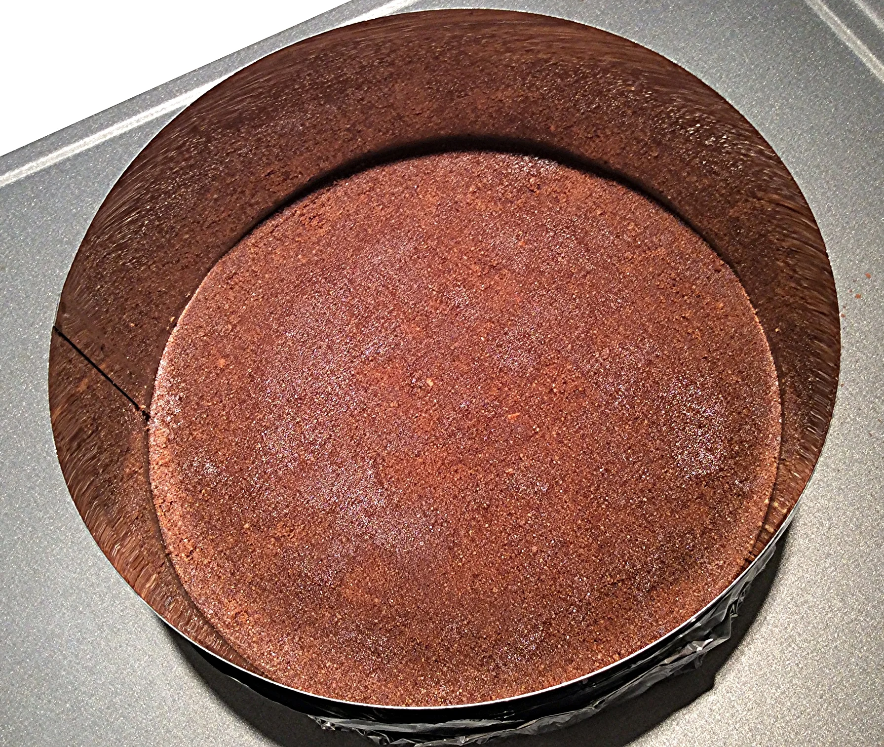 Coloque a farofa obtida com os ingredientes processados no fundo da forma (20 cm de diâmetro) e faça uma camada compacta, apertando-a com os dedos. Você pode usar uma colher ou um pote de vidro com o fundo liso para nivelar bem esta camada e deixa-la lisinha como a da foto.