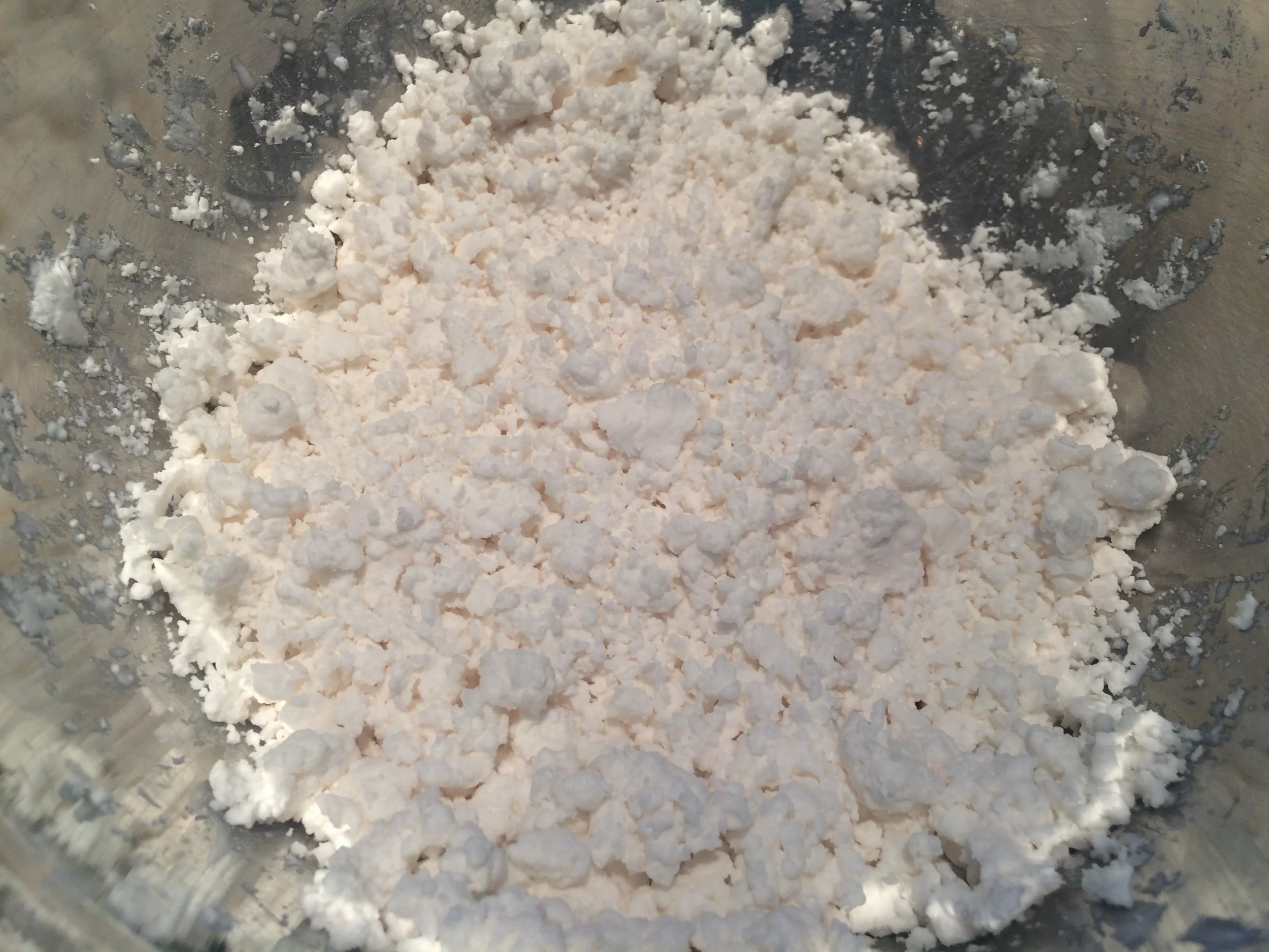 O que se deve ter em mente quando se faz tapioca é que a textura e aparência desejados são semelhantes às da ricota (veja foto acima). A melhor forma de atingí-lo com sucesso é ir adicionando a água aos poucos, incorporando-a com as mãos. Misture bem antes de adicionar mais água, para não correr o risco de obter aquela mistura que parece líquida, mas que fica dura com o toque, conhecida cientificamente como "líquido não-newtoniano". Por isso também é importante reservar um pouco do polvilho seco, antes de começar a hidrata-lo. Se você errar a mão na água e ficar com o "líquido-duro", é só usar o polvilho seco pra ajustar o teor de água da mistura. 
