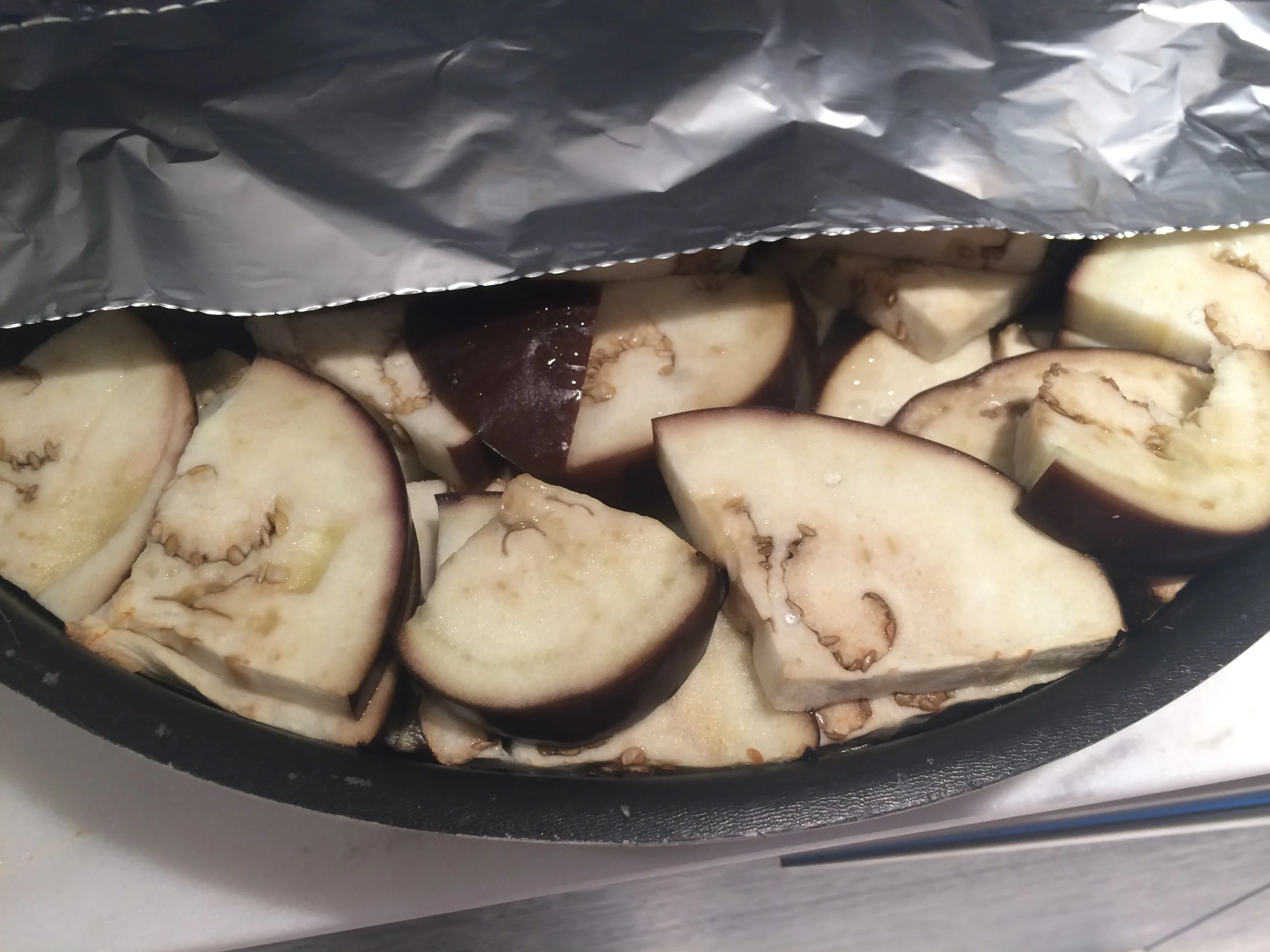Tampe a assadeira, vedando bem, com papel alumínio. Leve ao forno pré-aquecido a 180 graus, por 30 minutos. Vá checando de 30 em 30 minutos, até que as fatias estejam totalmente cozidas e meio murchas. 