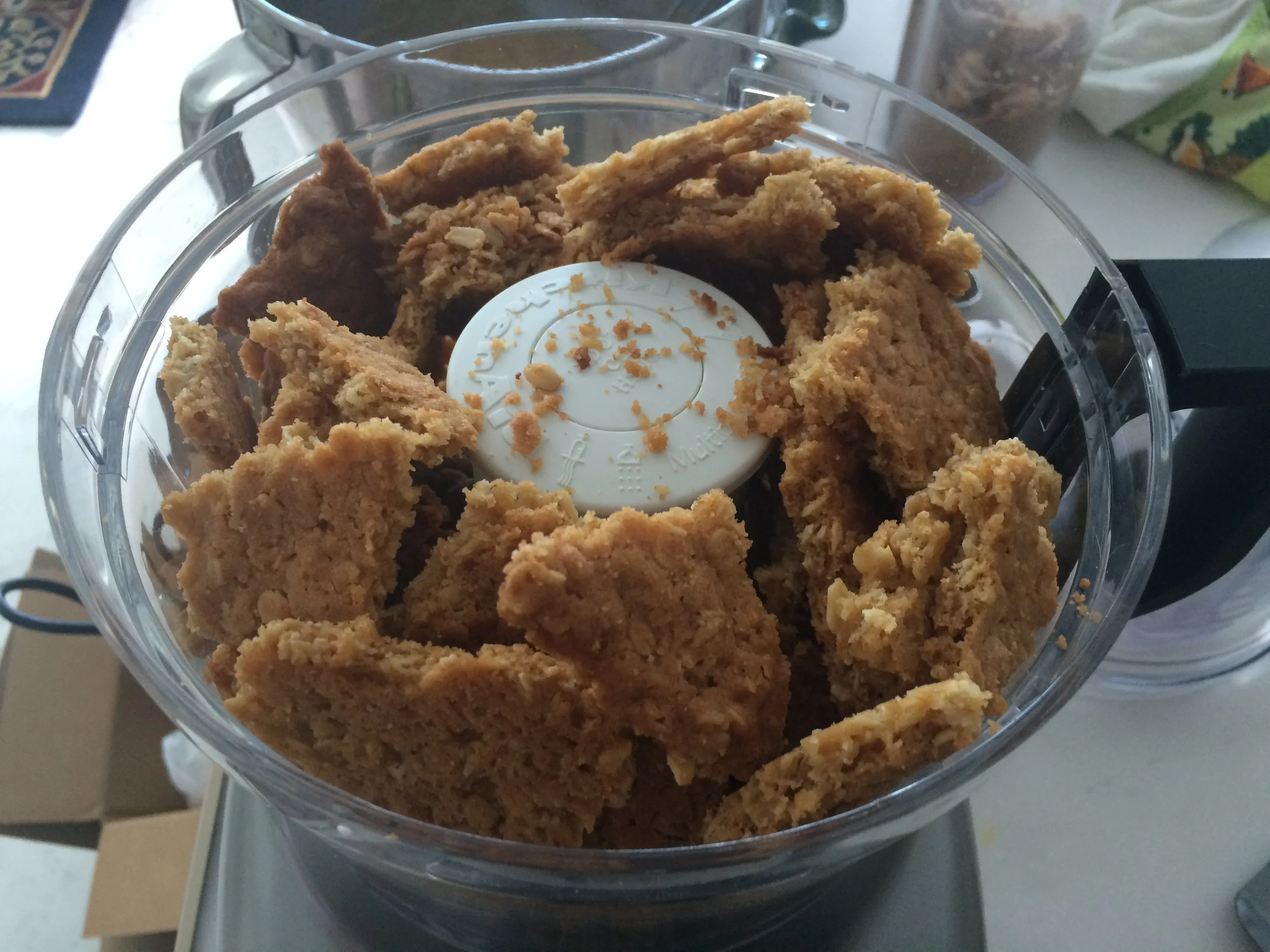 Coloque a massa quebrada de cookie , o açúcar e o sal num processador até virar uma farofa. Se você não tiver um processador de alimentos, pode usar um mixer ou o liquidificador. Só terá de dividir a massa em 3 ou 4 partes, pra ter condições de transformá-la em farofa. Se preferir fazer o trabalho a mão, um rolo de macarrão pode ajudar. Embrulhe os pedaços de massa num pano limpo, feche-o como um saco e segurando as extremidades com uma mão, apoiado sobre uma mesa firme, bata o rolo de massa em cima do pano até que esfarele tudo É um ótimo método para desestressar! 
