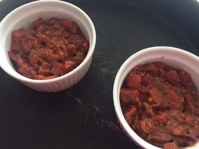 Distribua a pasta em partes iguais nos ramekins (ou você pode fazer tudo na mesma frigideira onde cozinhou tudo. Basta fazer alguns buracos na pasta para acomodar os ovos e as gemas.), fazendo um buraco no meio para os ovos. 