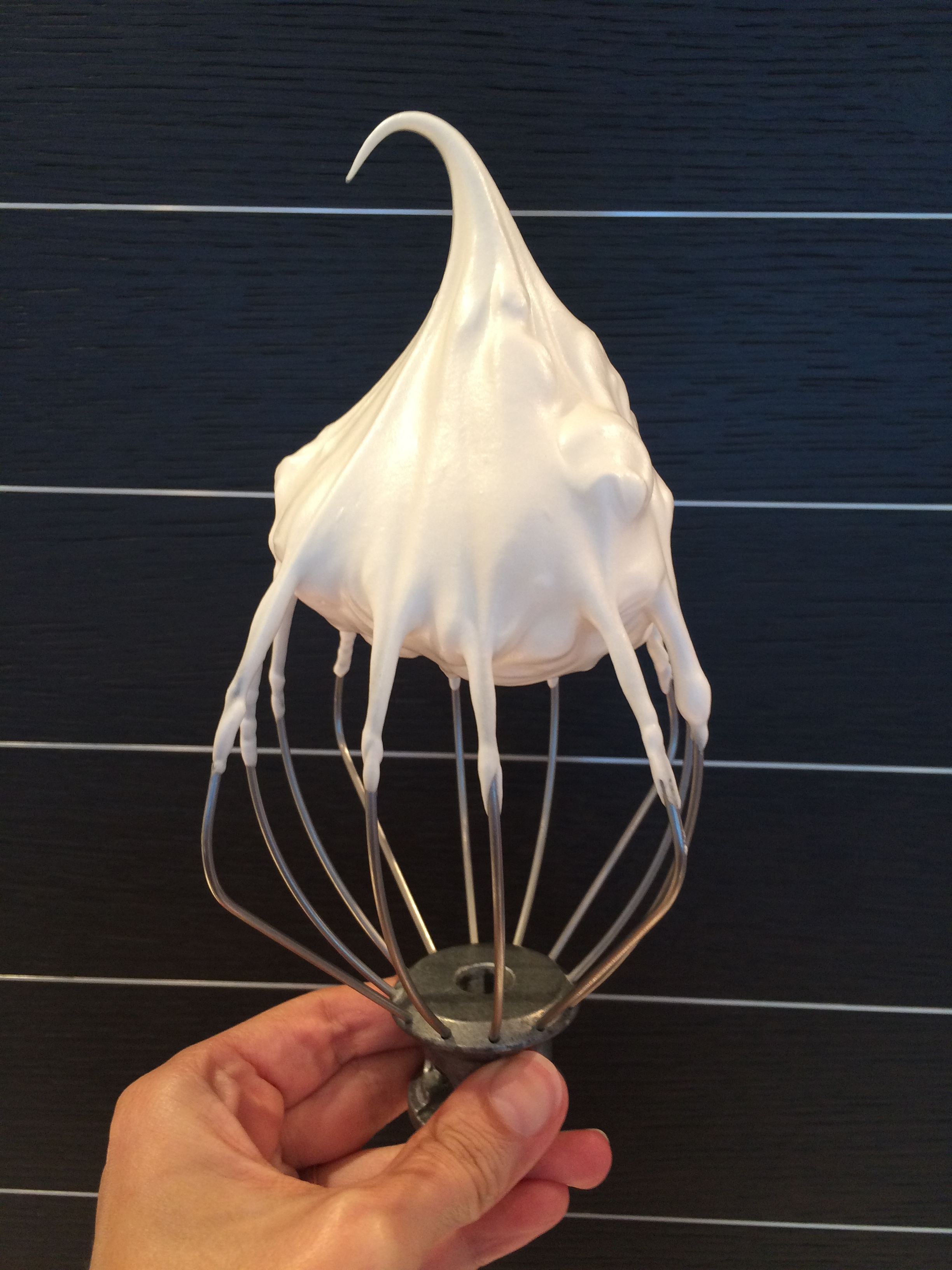 Bata o merengue até atingir este ponto.Brilhante e firme, a ponta não se curva por completo.
