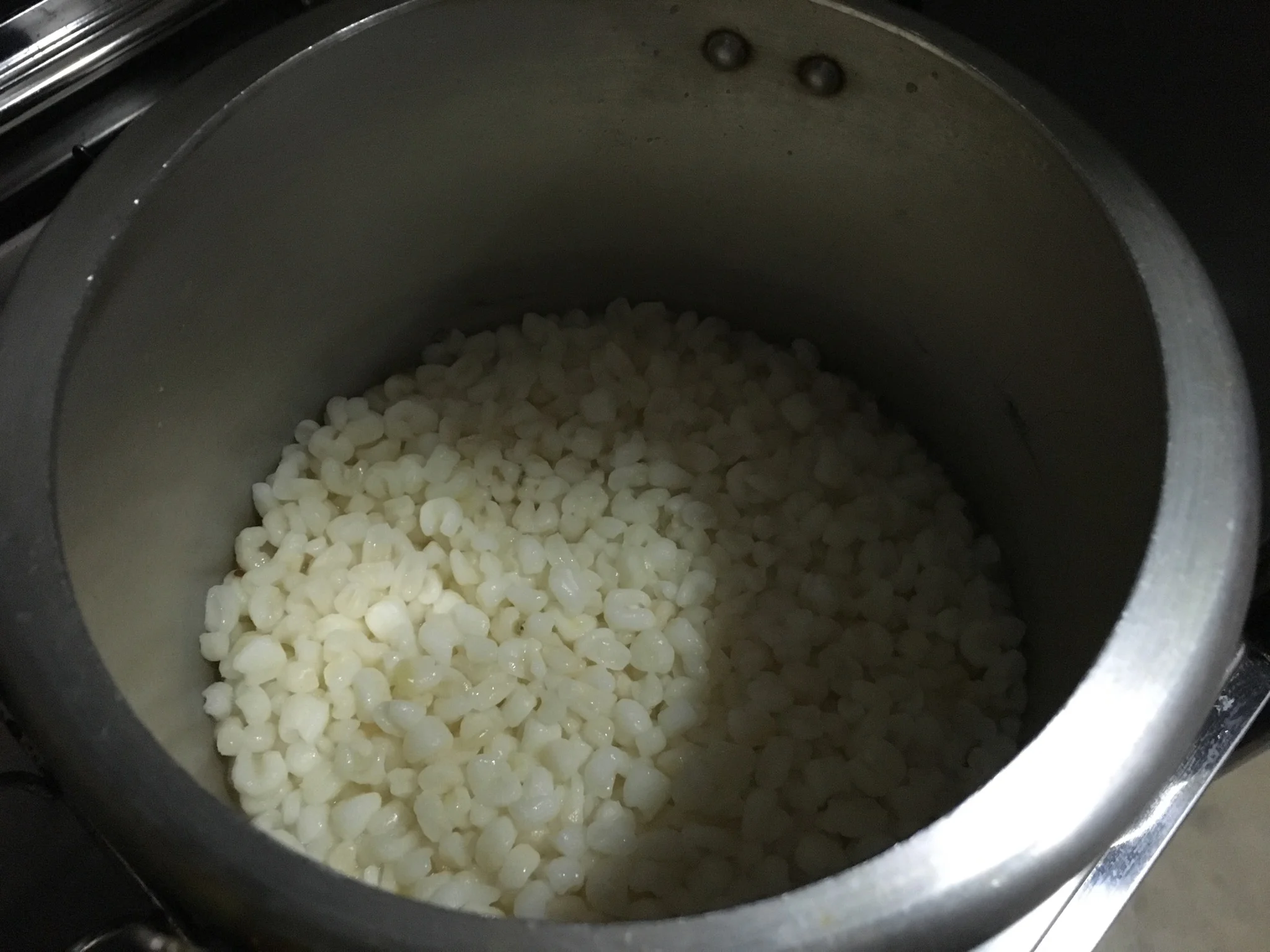 Deixe a canjica de molho em água filtrada por 6 horas. Depois, coloque os grãos hidratados numa panela de pressão e cubra-os com água filtrada, dois dedos acima dos grãos. Lembre-se de que a panela de pressão, por segurança, só pode ser preenchida por líquidos até metade de sua altura. Assim que a pressão pegar, cozinhe por 15 minutos. 