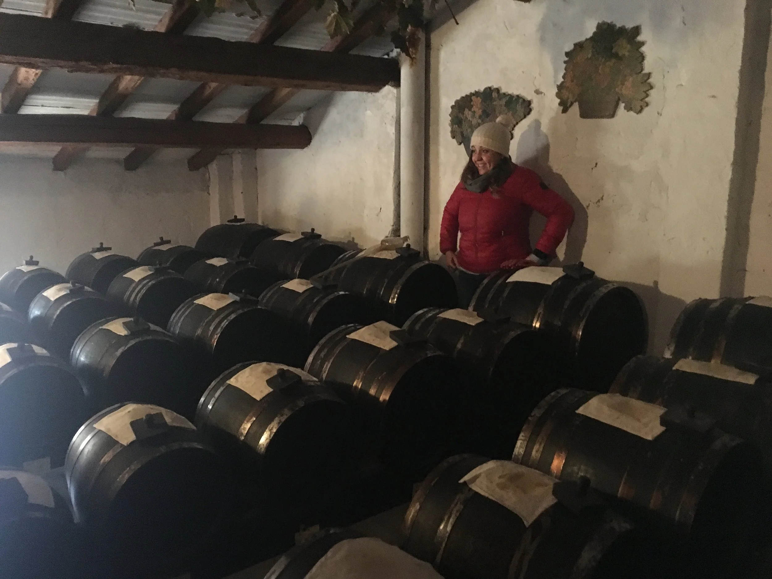 Nossa guia, Eleonora, pronta para nos contar sobre o processo produtivo artesanal do aceto balsâmico. Na frente dela, as baterias. Barris que vão diminuindo de tamanho até chegar a um bem pequeno, que fica na frente da bateria (fileira) e de onde sai o aceto finalmente pronto. Estes pedaços de pano tampam a abertura dos barris, deixando que o líquido respire e evapore. 