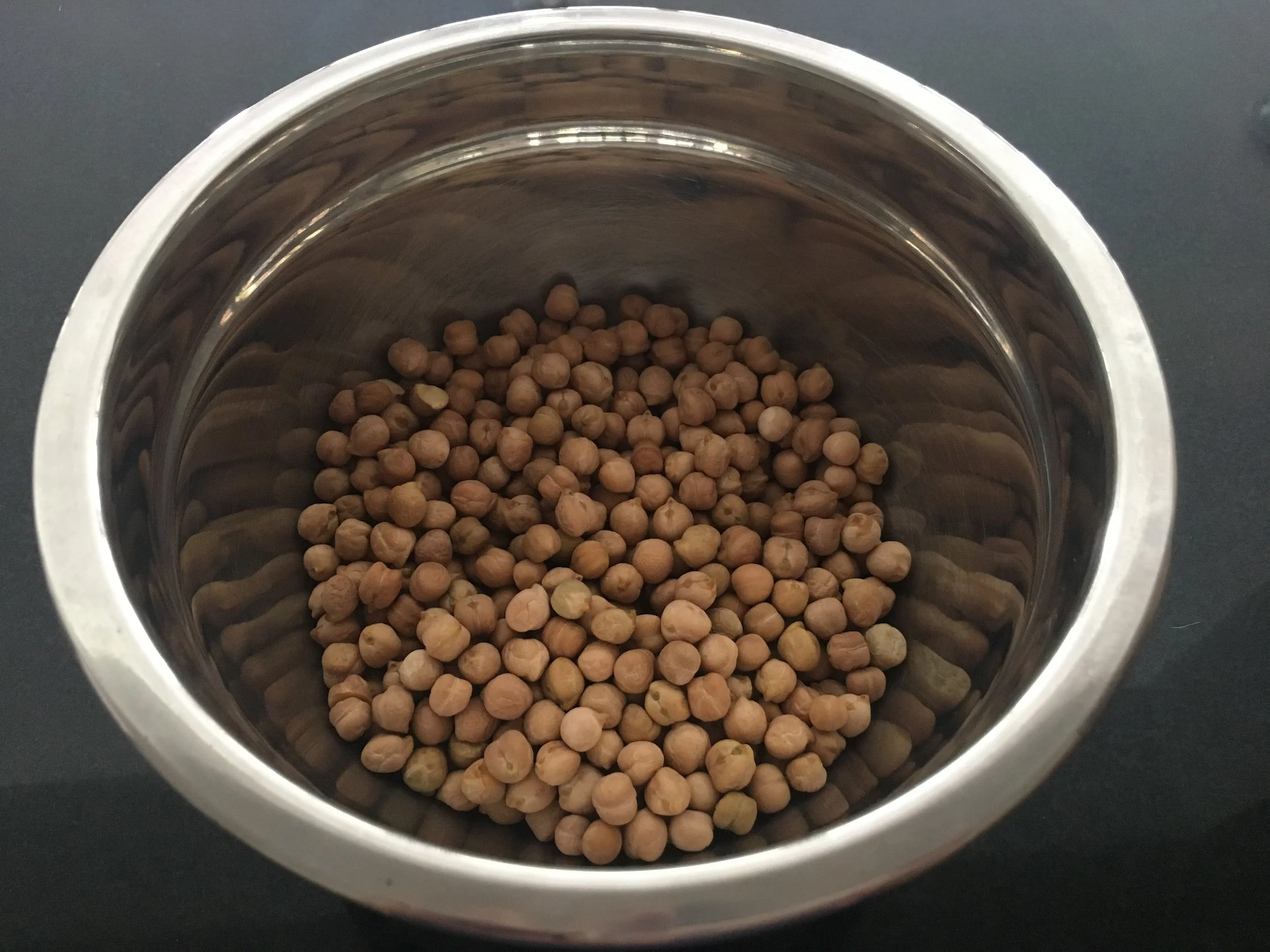 Ponha o grão de bico de molho por 12 até 24 horas. Os grãos irão mais do que dobrar de volume, portando coloque 3 vezes mais água que as medidas de grãos. Cubra e leve a vasilha à geladeira.
