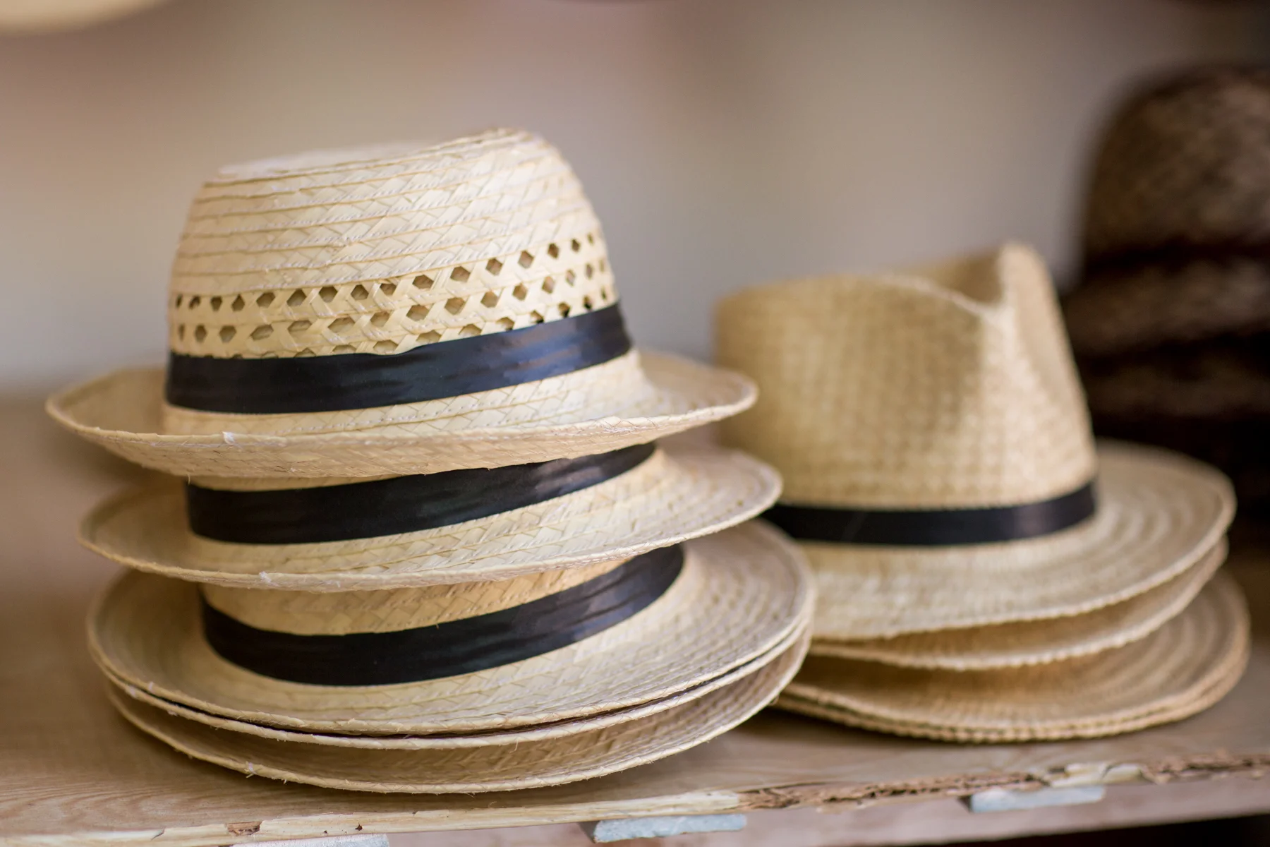 Stacks of Cuban hats with black rim.