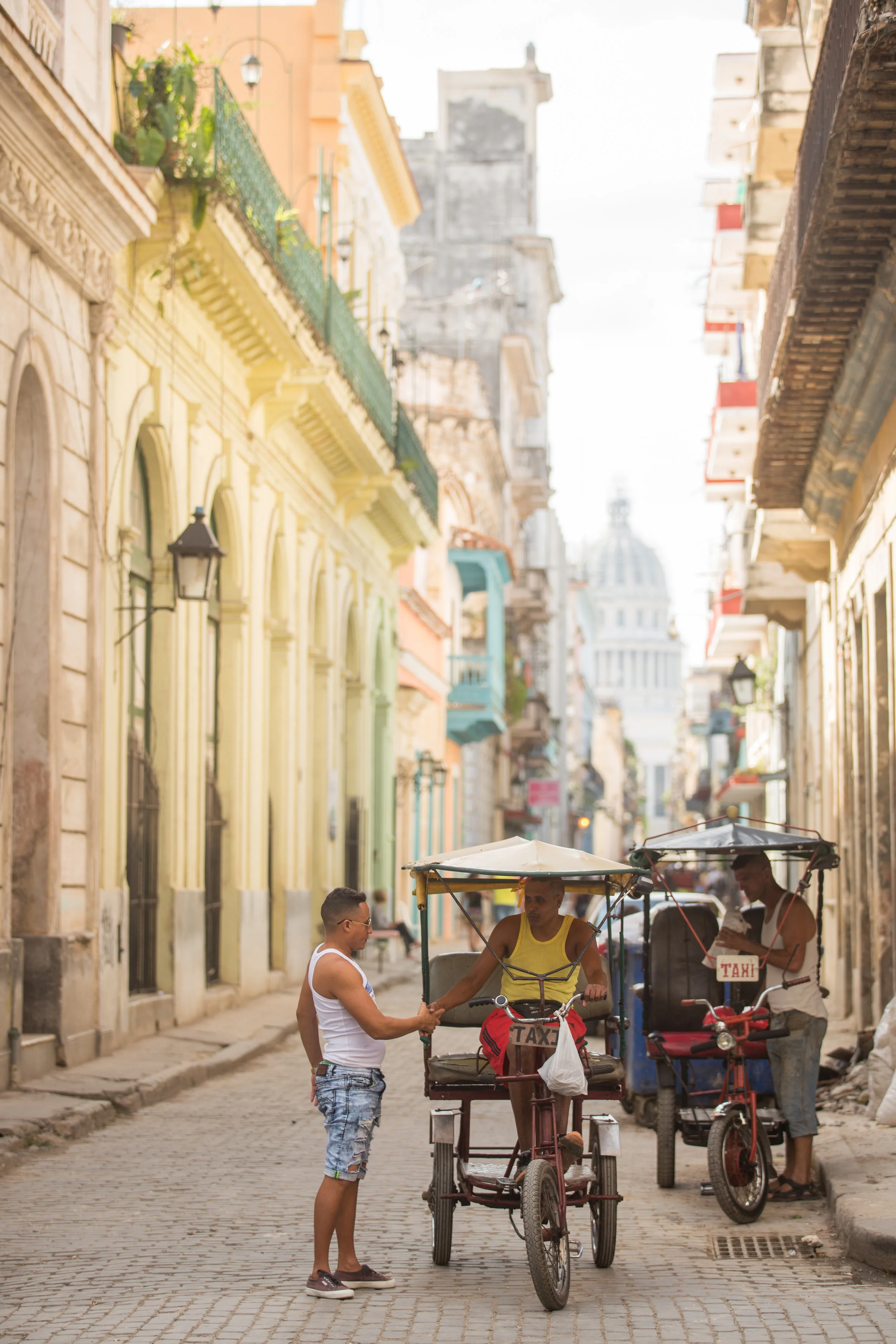 Havana's bicycle taxis on the streets of Old Havana with the captial building as a backdrop.
