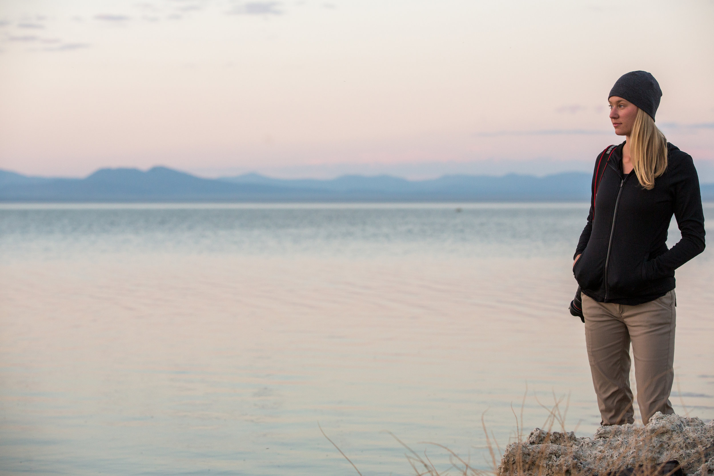  Young woman hikes with a camera at South Lake Tufa Area, Mono Lake, California. 