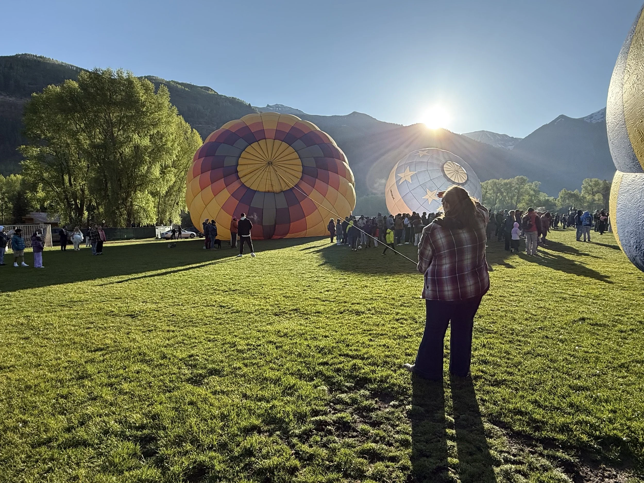 Crew member holding crownlike of hot air balloon in Mountains