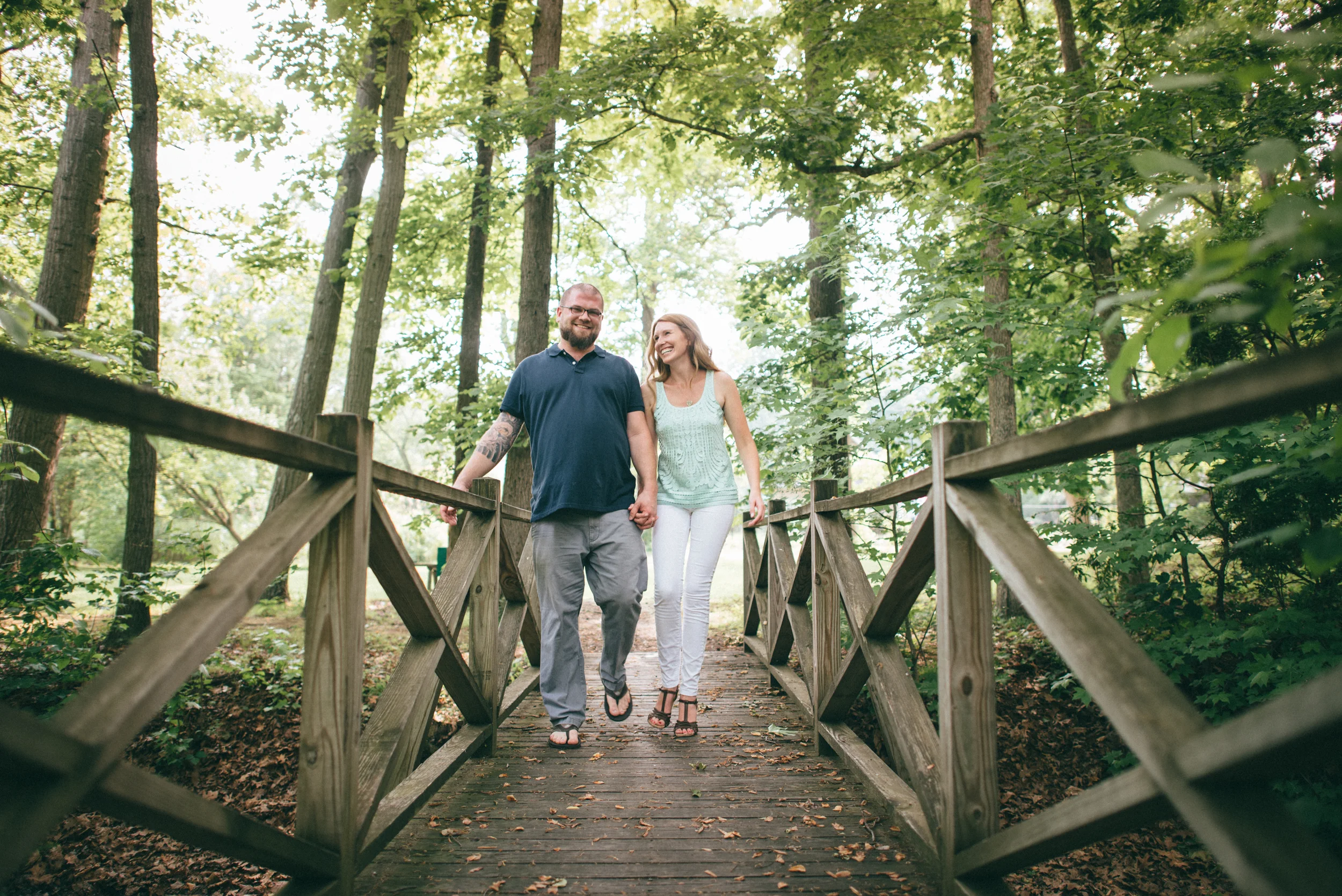 bride and groom walking over bridge