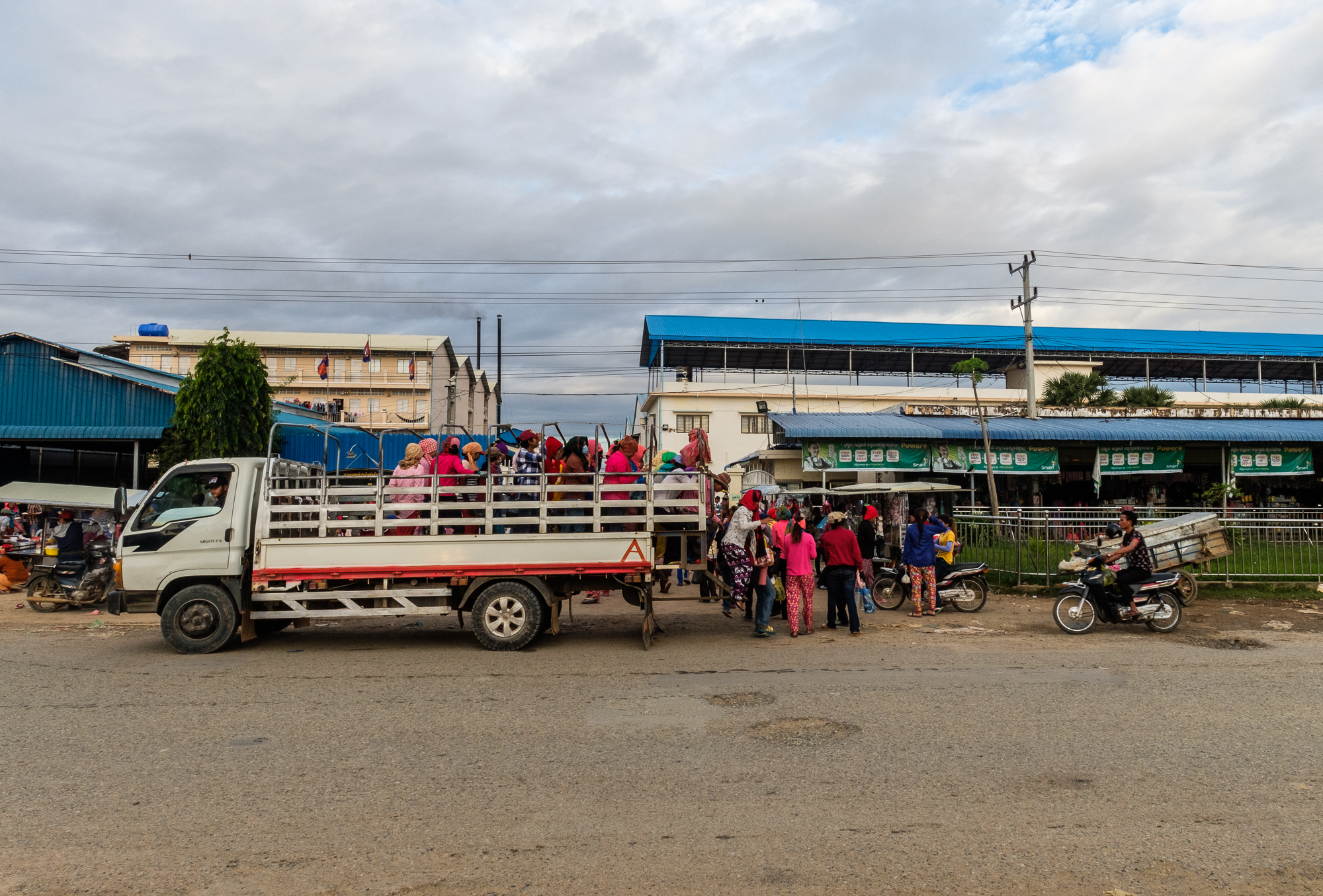 Workers arrive at the garment factory. Close to 40% of workers choose the cheap yet dangerous option of taking open topped trucks to work. With minimum wage being so low, $10 transport a month is many workers only option.