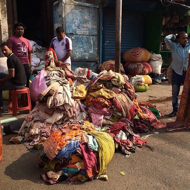 Sorting saris on the road for sale and recycling