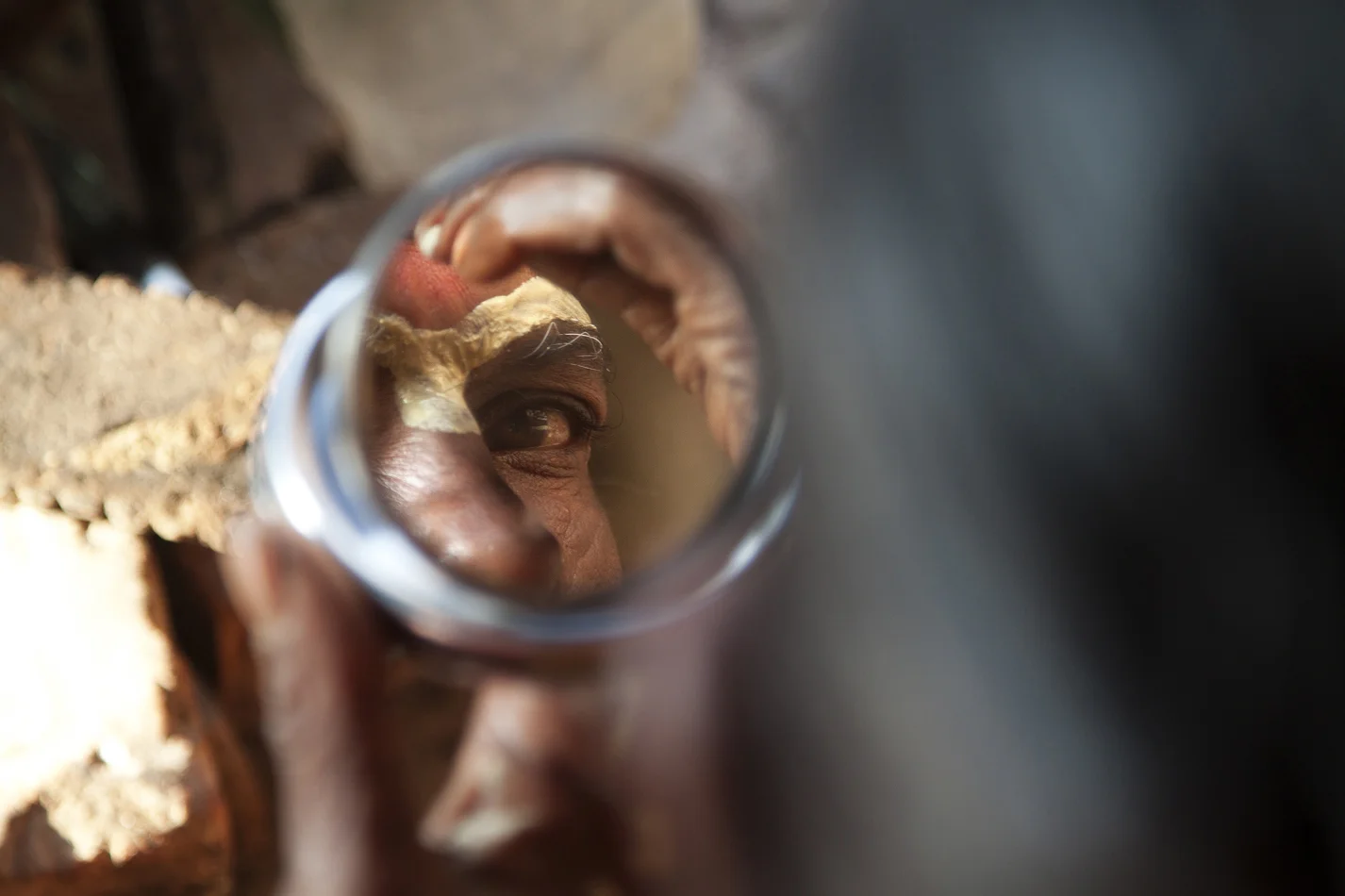  Nepal, a Sadhu near Pashupatinath temple. Painting his face before starting the day, daily ritual. 