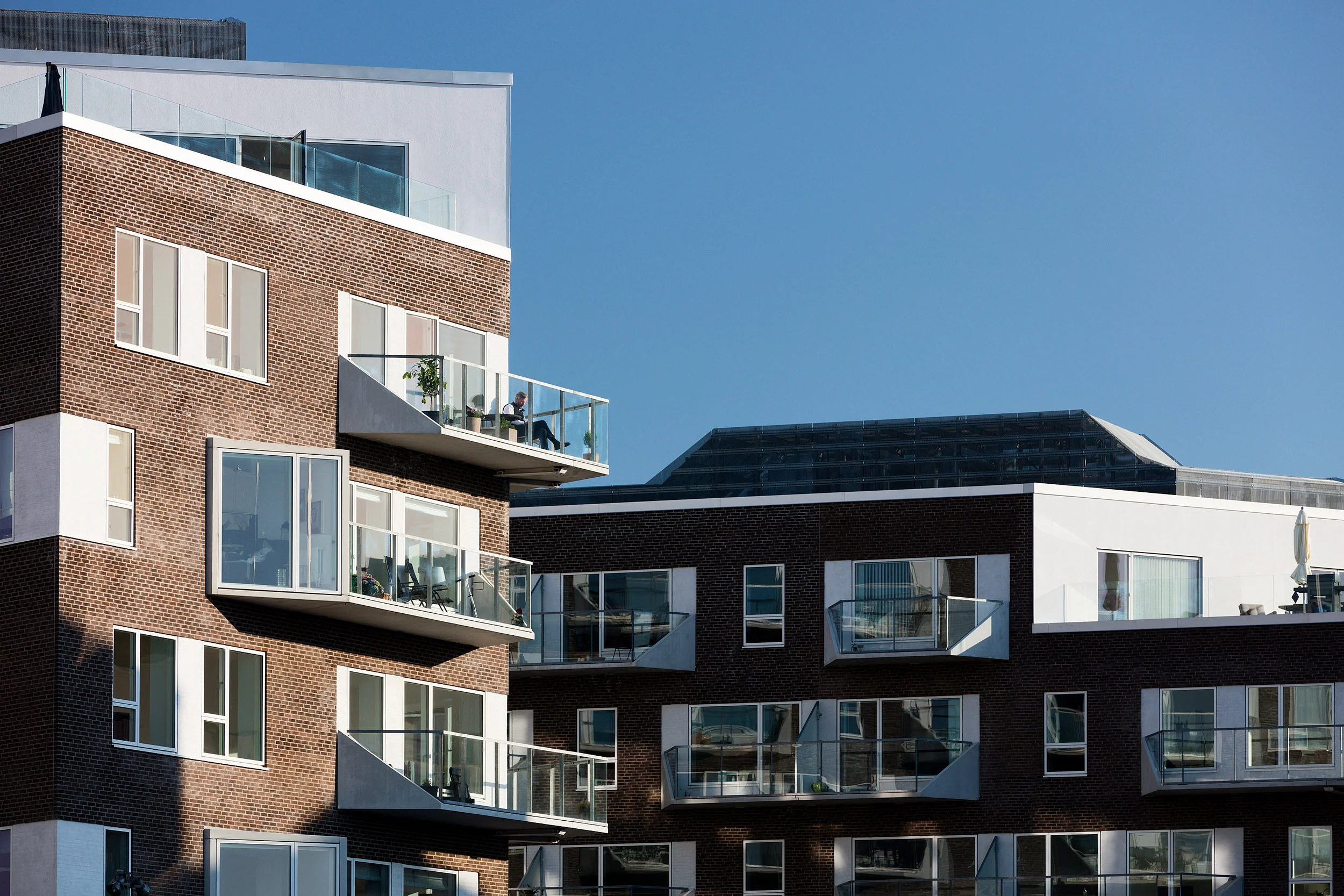 Residential housing, Skibbroen, realised by Holscher Nordberg Architects. Photographed from early morning throughout the day, letting the sun emphasise the various aspects of the buildings character. The special life that characterizes Skibbroen occurs due to users’ various activities and the mix of tranquility, activity, transit and practical doings.The uniqueness of the channel and harbor space is maintained. Photographed from early morning throughout the day, letting the sun emphasise the various aspects of the buildings character. 