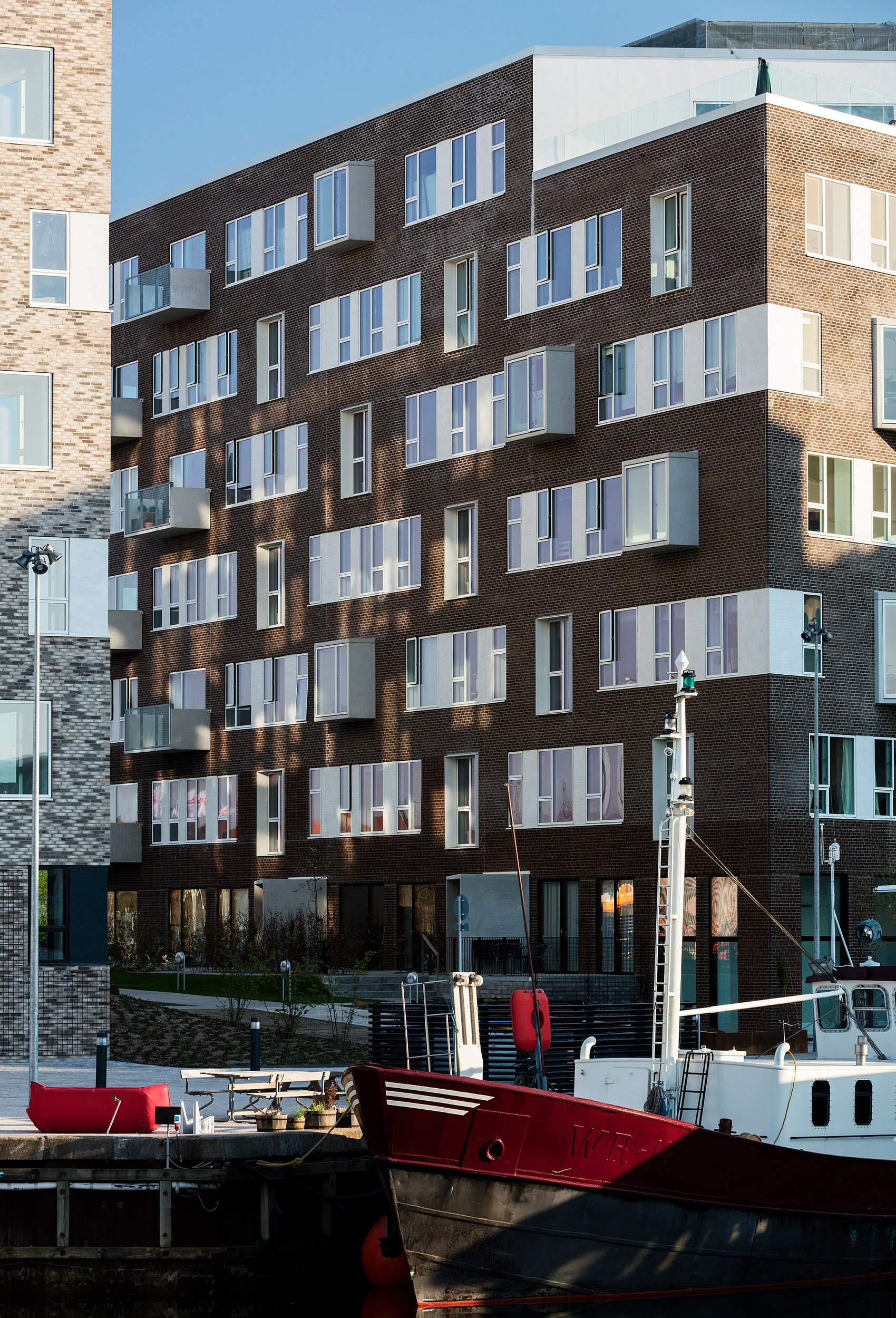 Residential housing, Skibbroen, realised by Holscher Nordberg Architects. Photographed from early morning throughout the day, letting the sun emphasise the various aspects of the buildings character. The special life that characterizes Skibbroen occurs due to users’ various activities and the mix of tranquility, activity, transit and practical doings.The uniqueness of the channel and harbor space is maintained. Photographed from early morning throughout the day, letting the sun emphasise the various aspects of the buildings character. 