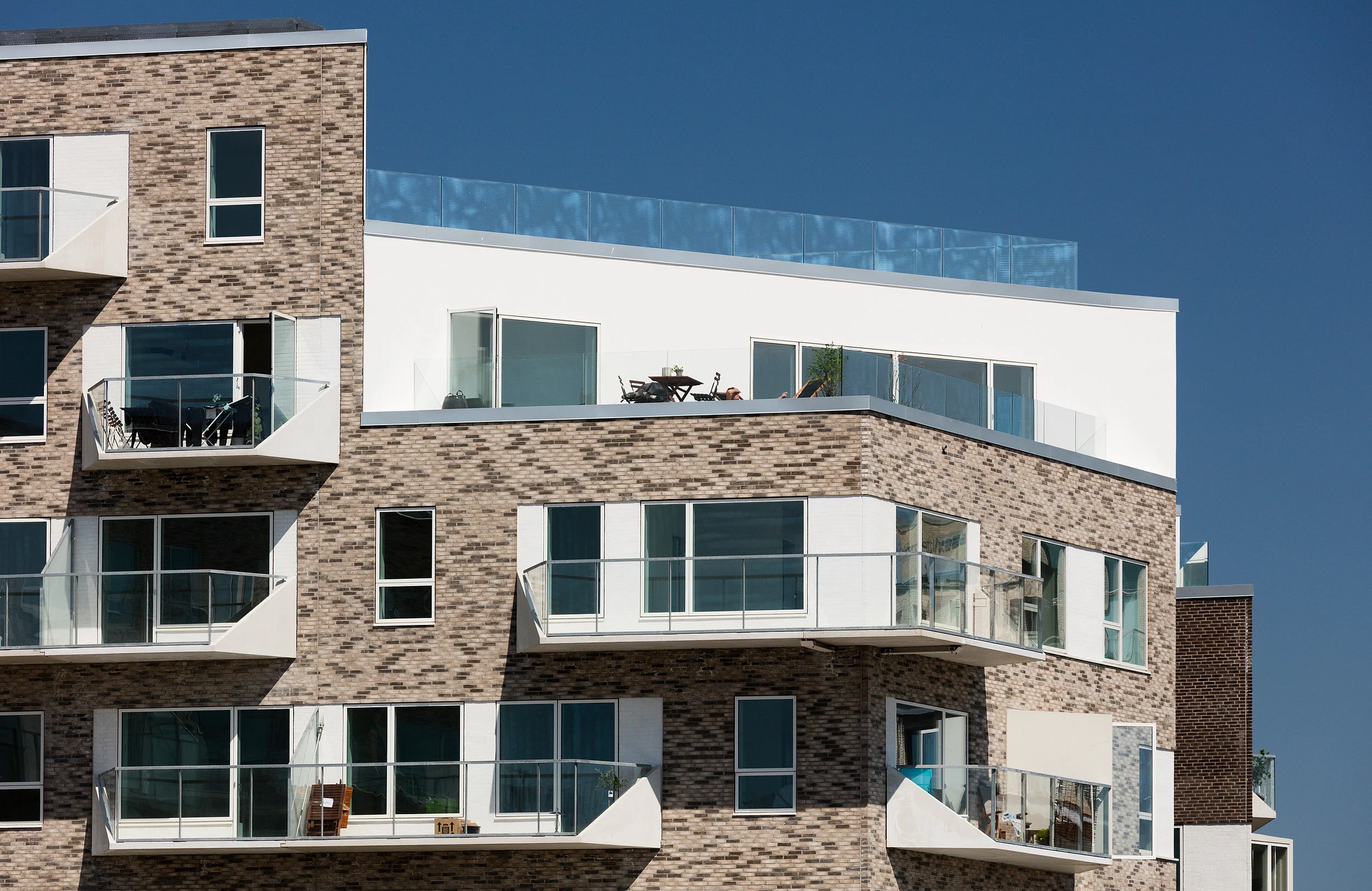 Residential housing, Skibbroen, realised by Holscher Nordberg Architects. Photographed from early morning throughout the day, letting the sun emphasise the various aspects of the buildings character. The special life that characterizes Skibbroen occurs due to users’ various activities and the mix of tranquility, activity, transit and practical doings.The uniqueness of the channel and harbor space is maintained. Photographed from early morning throughout the day, letting the sun emphasise the various aspects of the buildings character. 