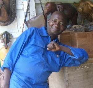 Divine, an artist in Ghana, is posed with a wooden chest, before he carved it for The Yonkofa Project. To the left, is a picture of the completed chest, which will be available at our event, Sept. 13, 2014.
