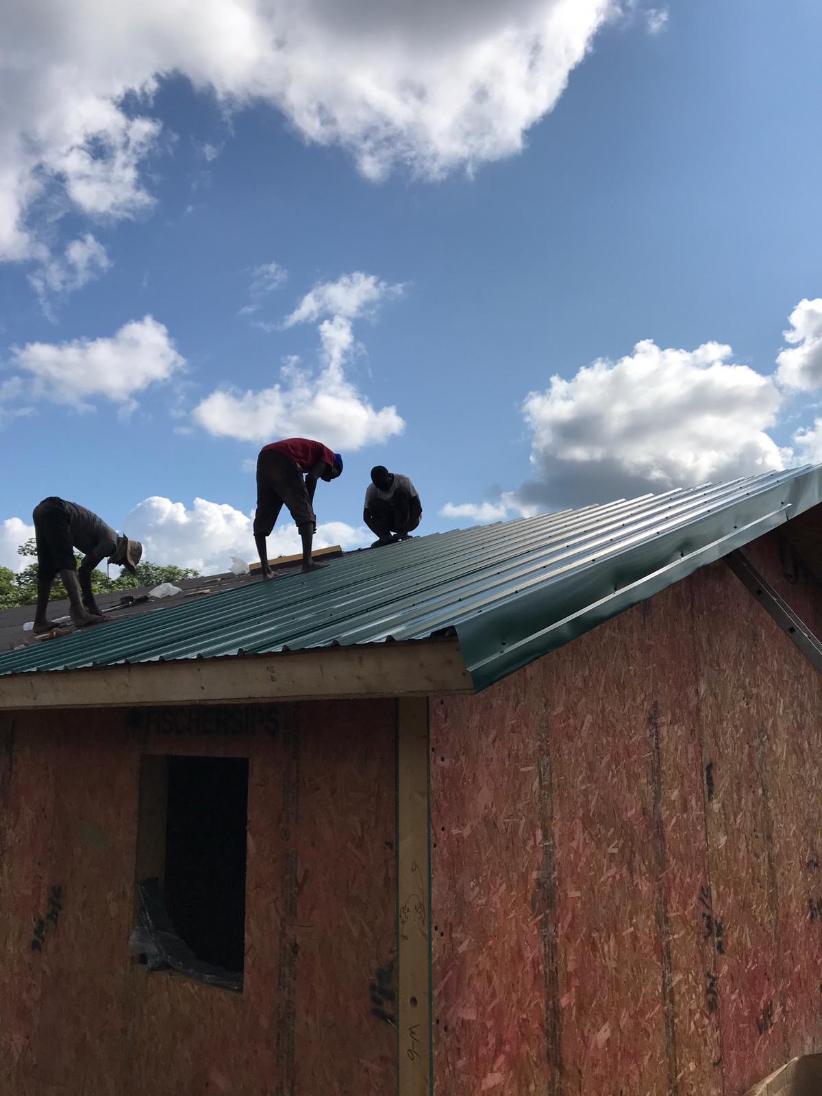 Putting on the metal roofing.