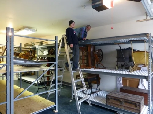 George Italiano, on top of the shelf, and one of the movers, arranging things at the new location.